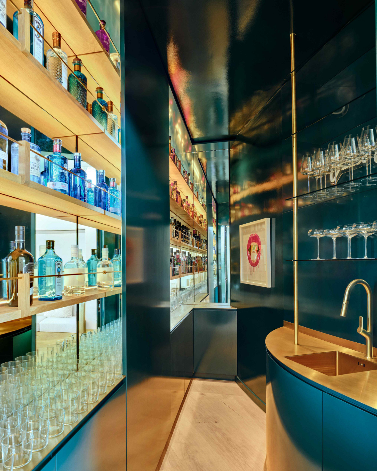 The hidden bar in deep teal gloss concealed behind the curved concrete wall