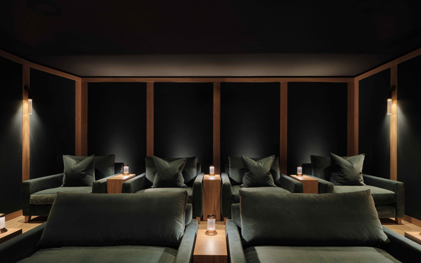 The cosy cinema room with bespoke seating and lighting fixtures by J Adams