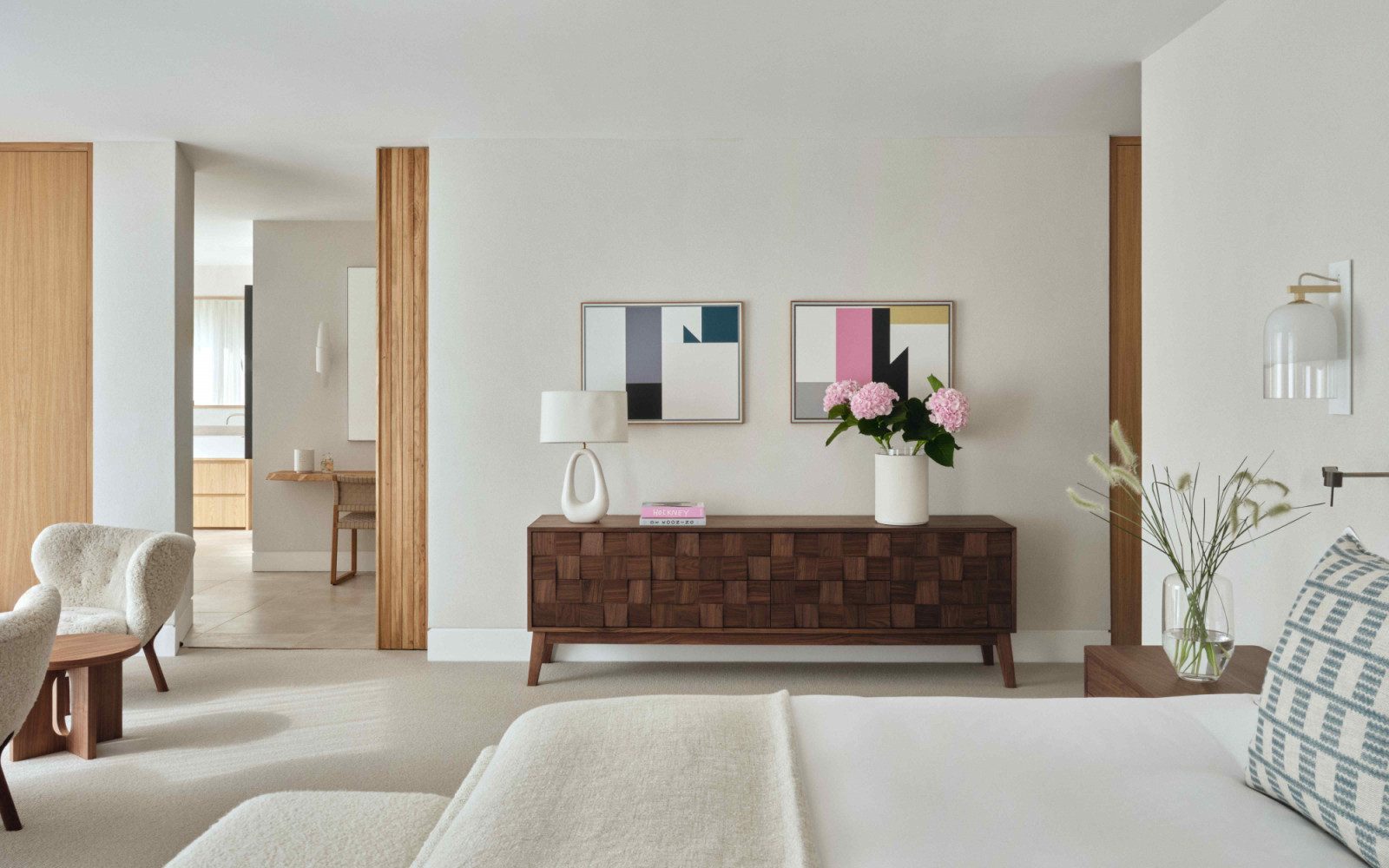 The restrained palette provides a calm backdrop for the homeowners’ art collection
