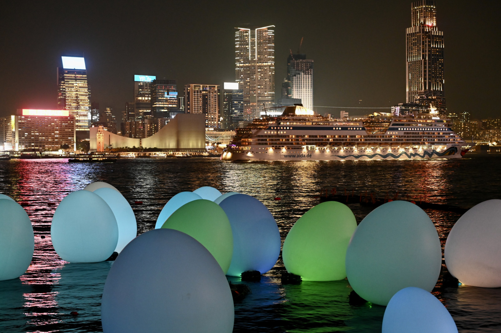 HONG KONG, CHINA - MARCH 25: Luminous installations by digital art group teamLab are on display at Victoria Harbour during an exhibition on March 25, 2024 in Hong Kong, China. Giant glowing egg-shaped objects span across the lawns of Tamar Park and extend to the Victoria Harbour during the 'TeamLab: Continuous' exhibition. (Photo by Li Zhihua/China News Service/VCG via Getty Images)