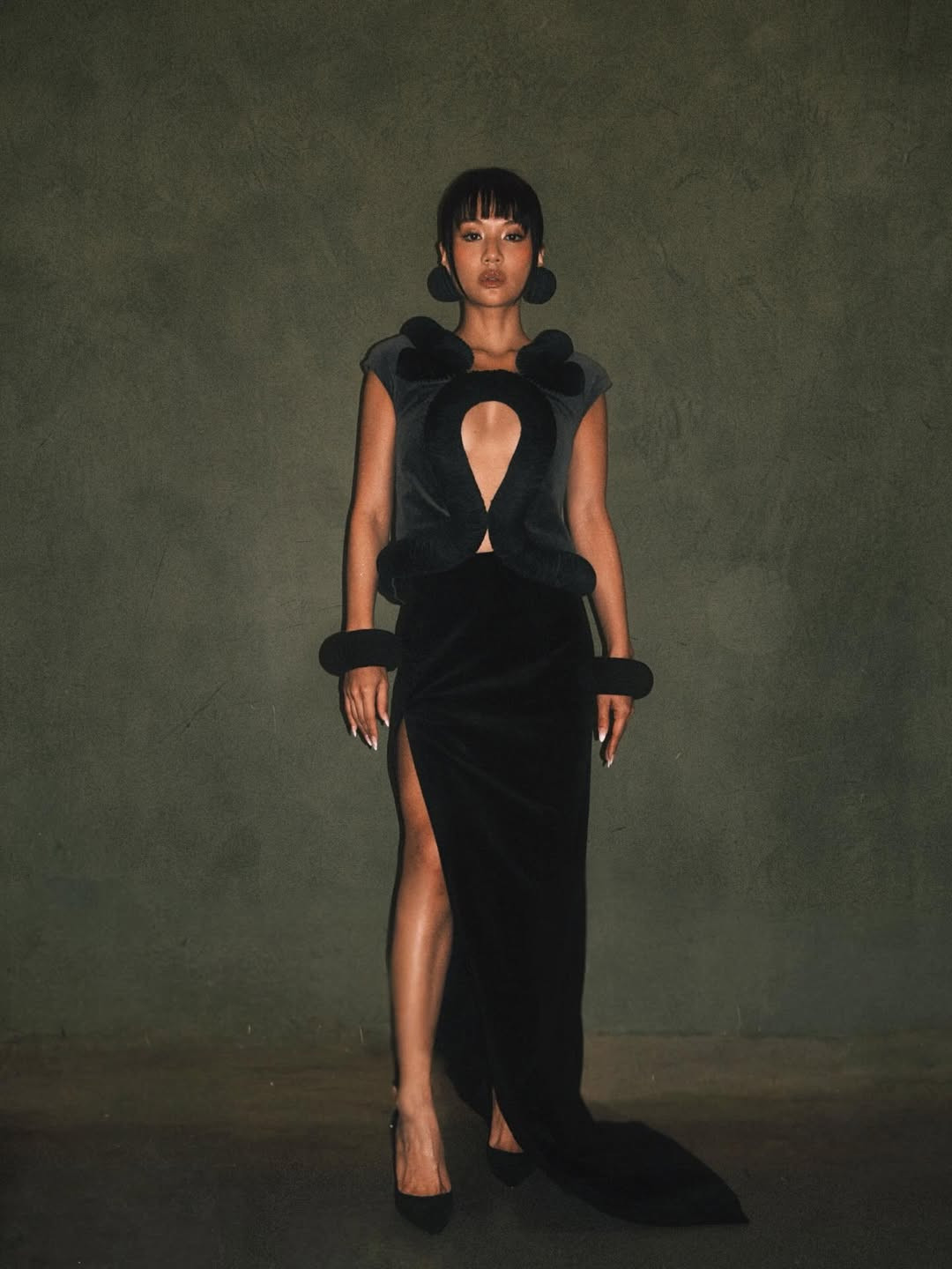 Black velvet with curved cut-outs showcases sculptural tailoring and refined drama (Photo: Rei Ami/Instagram)