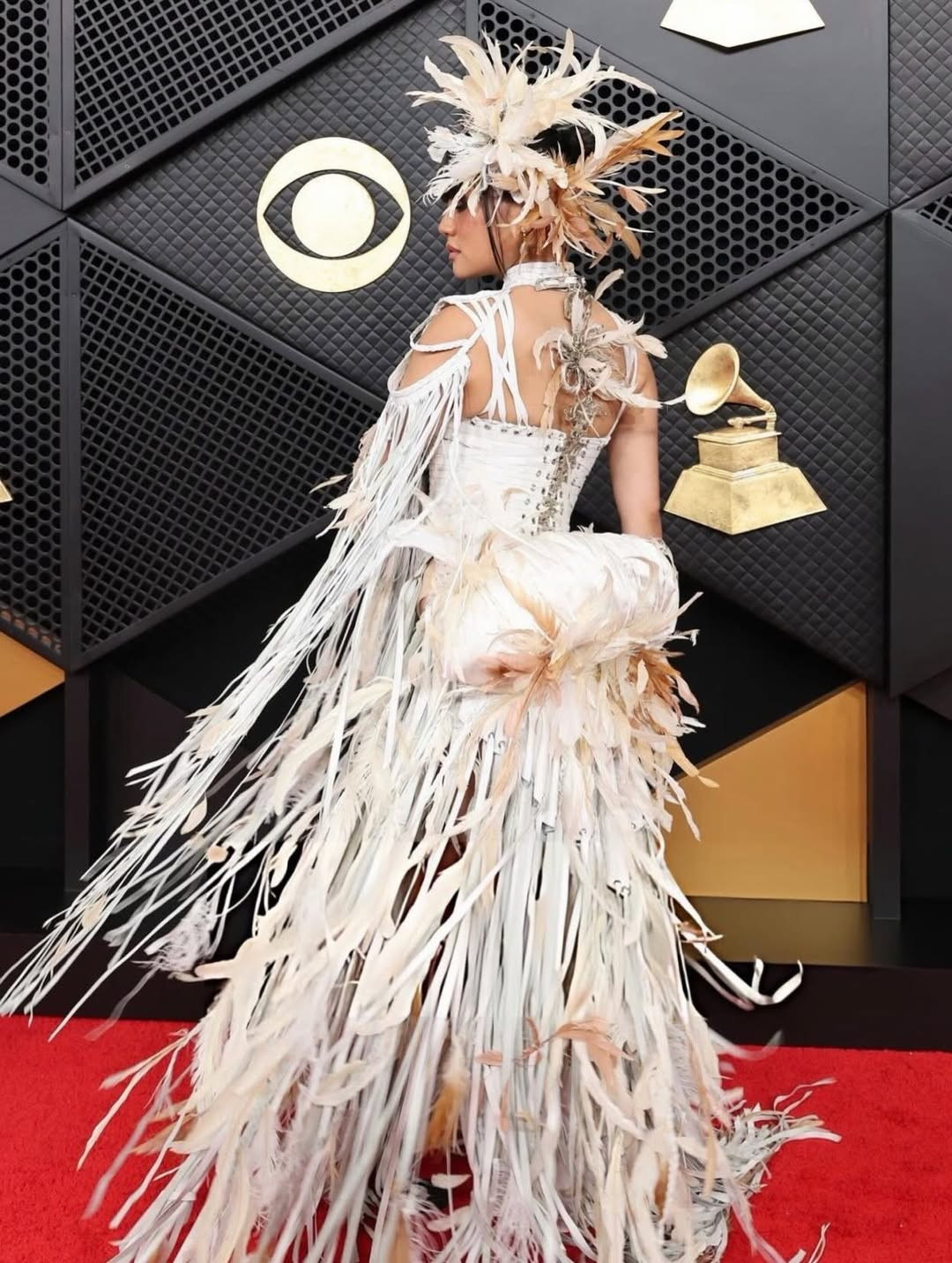 Layered feathers and subtle mugunghwa motifs blend movement and cultural reference in Rei Ami’s look (Photo: Rei Ami/Instagram)