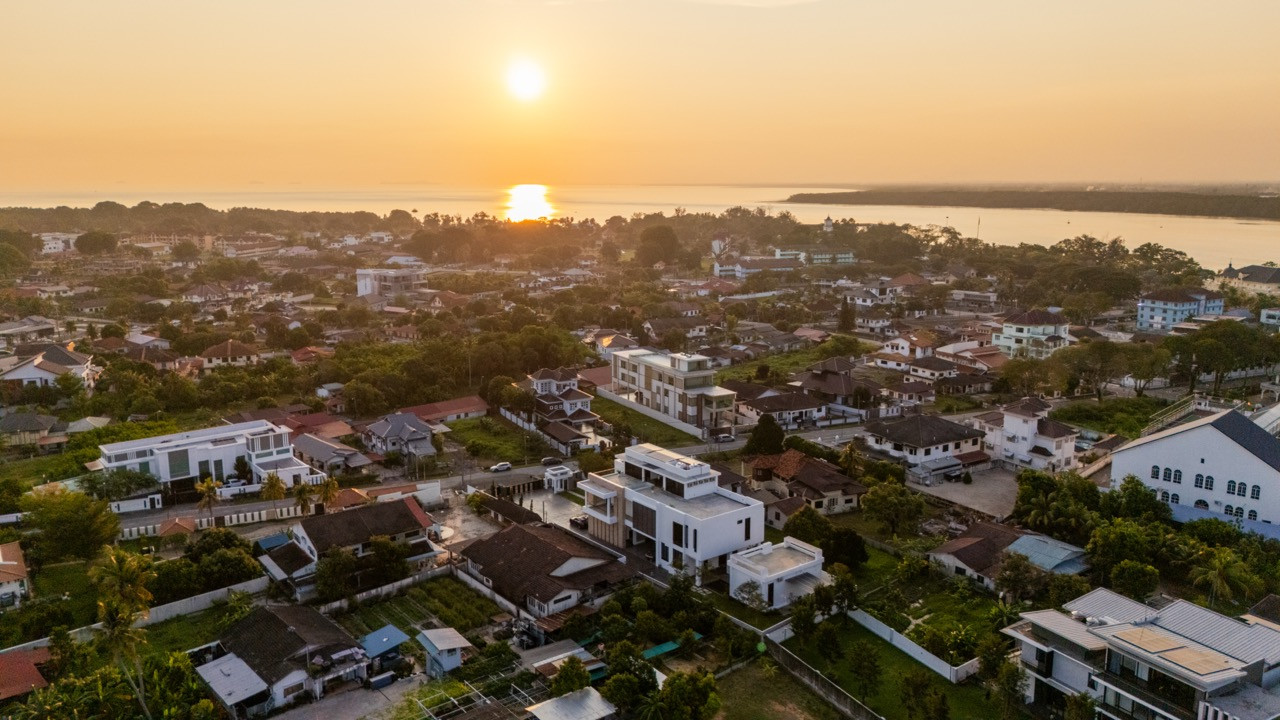 The residence sits within Muar's established riverside neighbourhood, visible here at dusk with the Muar River and Strait of Malacca beyond