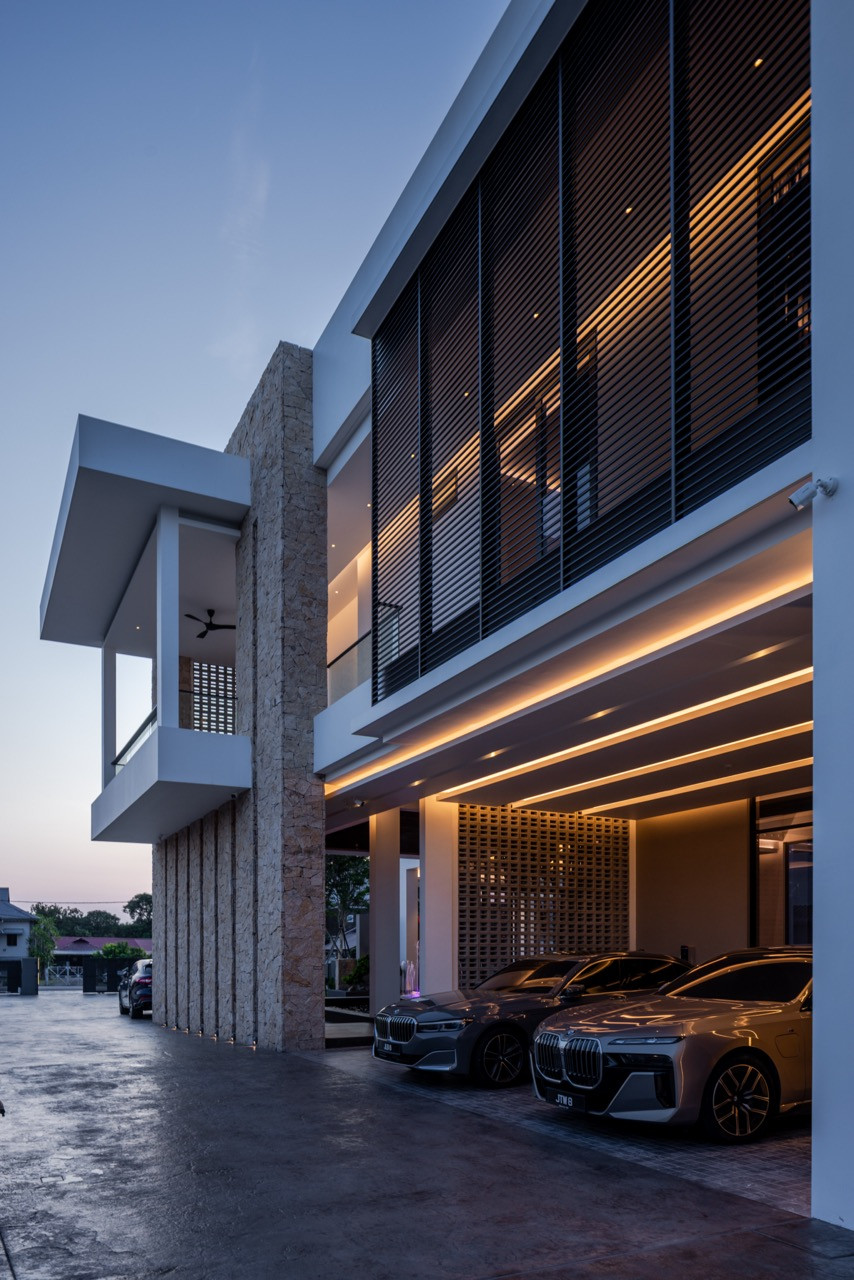 The third-floor sky garden at dusk, with potted palms lining the parapet wall, a small plunge pool at the centre, and the gym room opening to the terrace through full-height glazed doors overlooking the Muar skyline