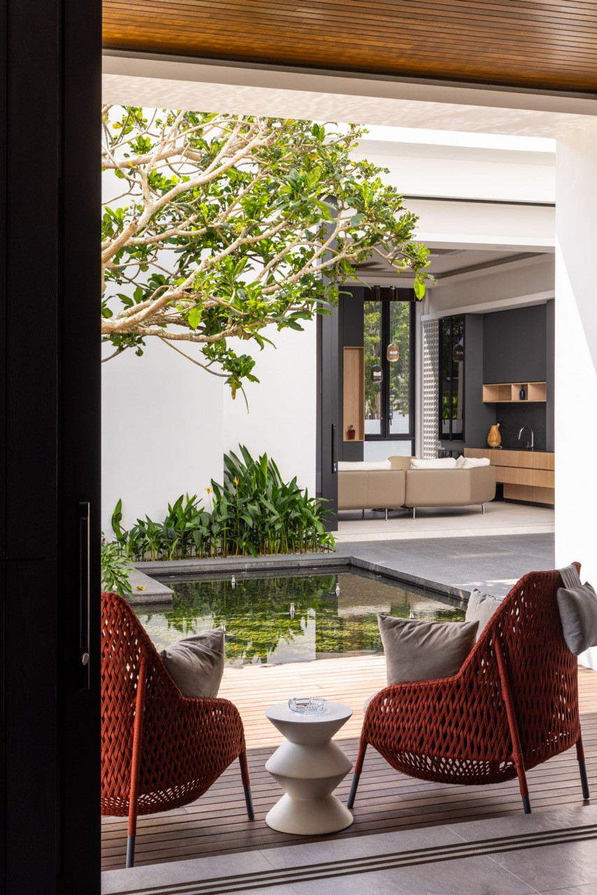 The outdoor terrace of the rear villa, viewed from the interior through a wide pivoting doo