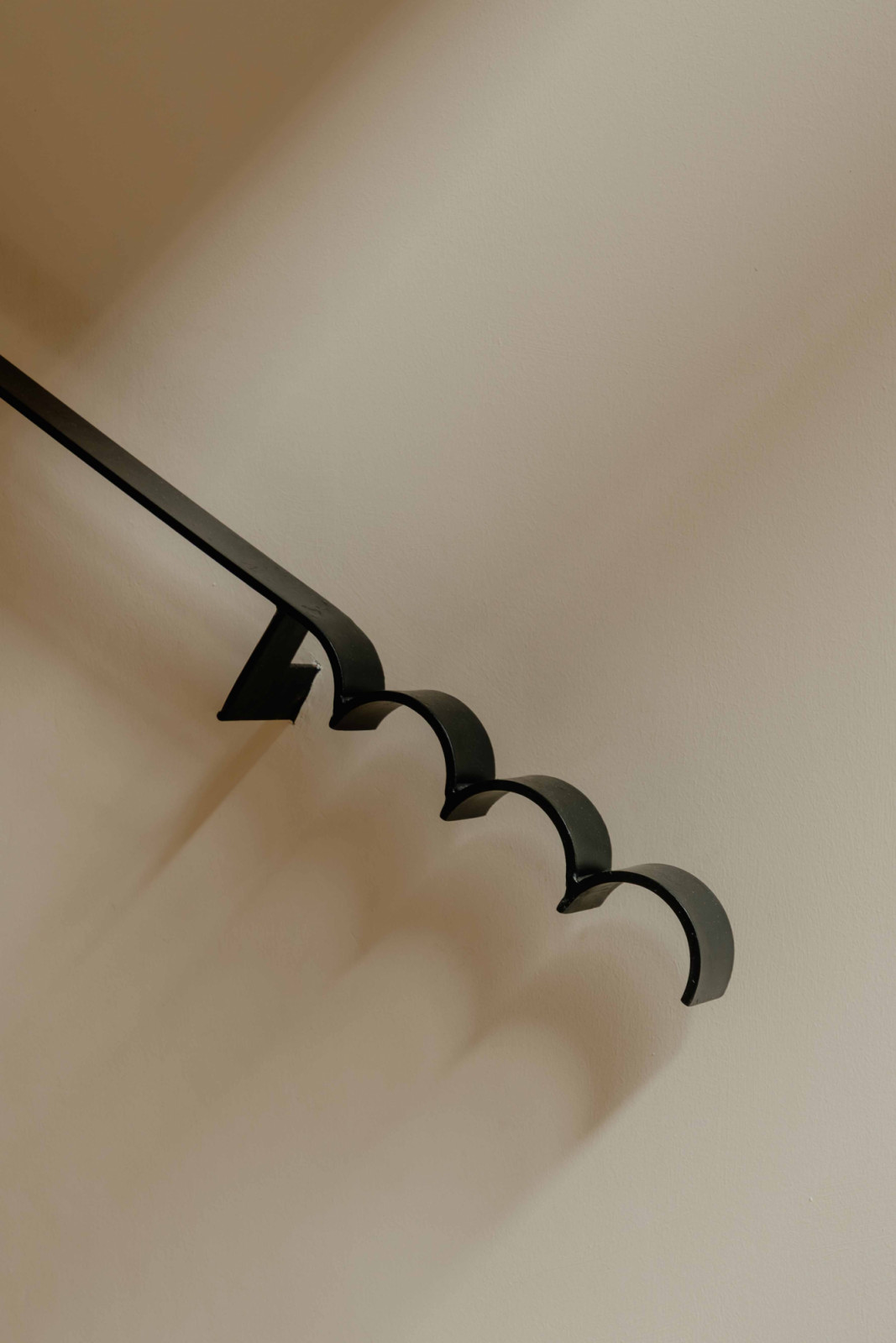 The scalloped trellis detailing continues into the handrail design, carrying a rhythmic motif through the home’s vertical circulation