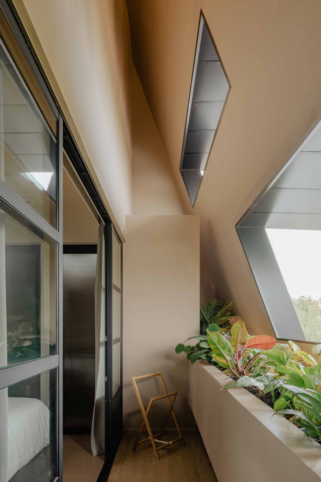 A small balcony in front of the master bedroom, sheltered from street view by the giant roof