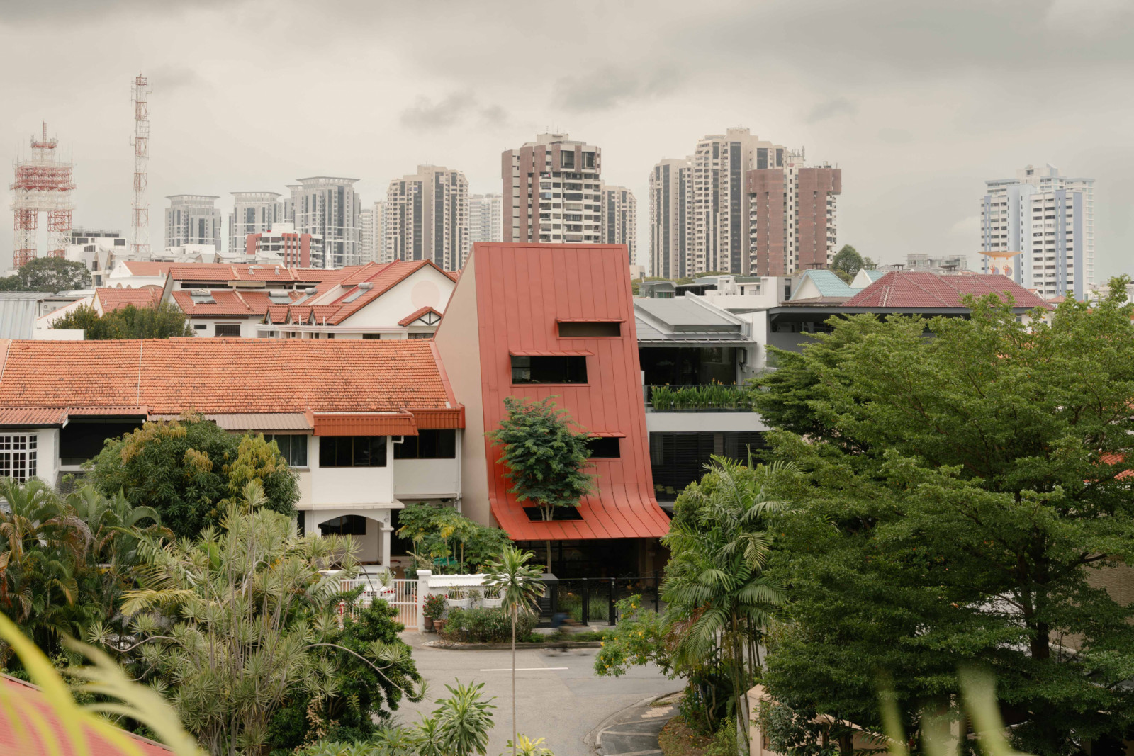 The 3,112 sq ft Giant Roof House paints a distinct look in its neighbourhood in Singapore’s east with a “giant” roof that covers the extended portion of the house in front of the existing structure