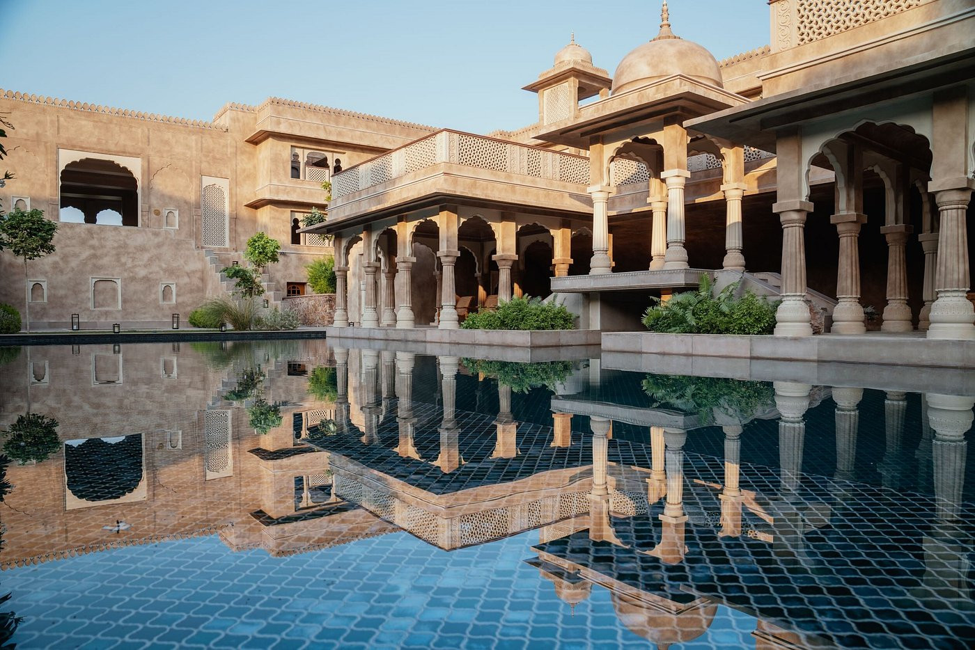 The collonaded pavilion beside the Rani Bagh pool reflects in the dark-tiled water at dusk; the carved marble columns are original to the fort’s restoration.