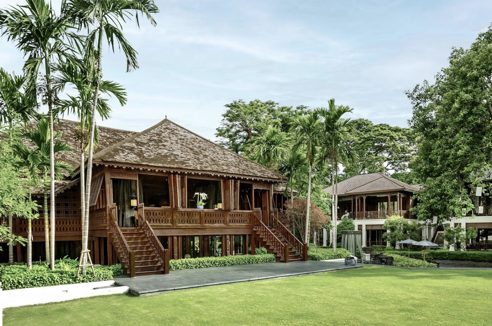 The original Borneo Company teak house, alongside one of the newer Lanna-style guest buildings designed by Habita Architects