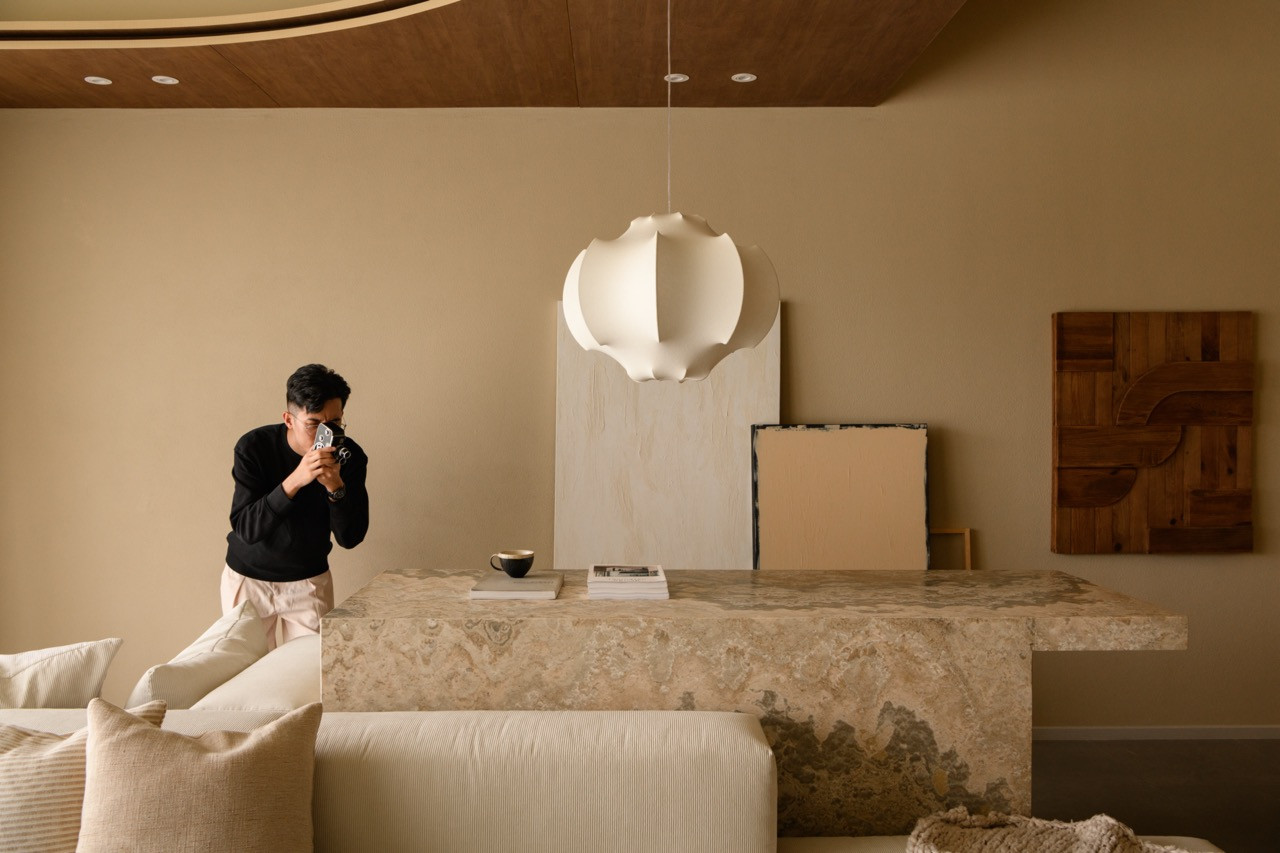 The living room shows the marble-topped console behind the sofa, a globe-form pendant light, and a curved wood ceiling detail overhead