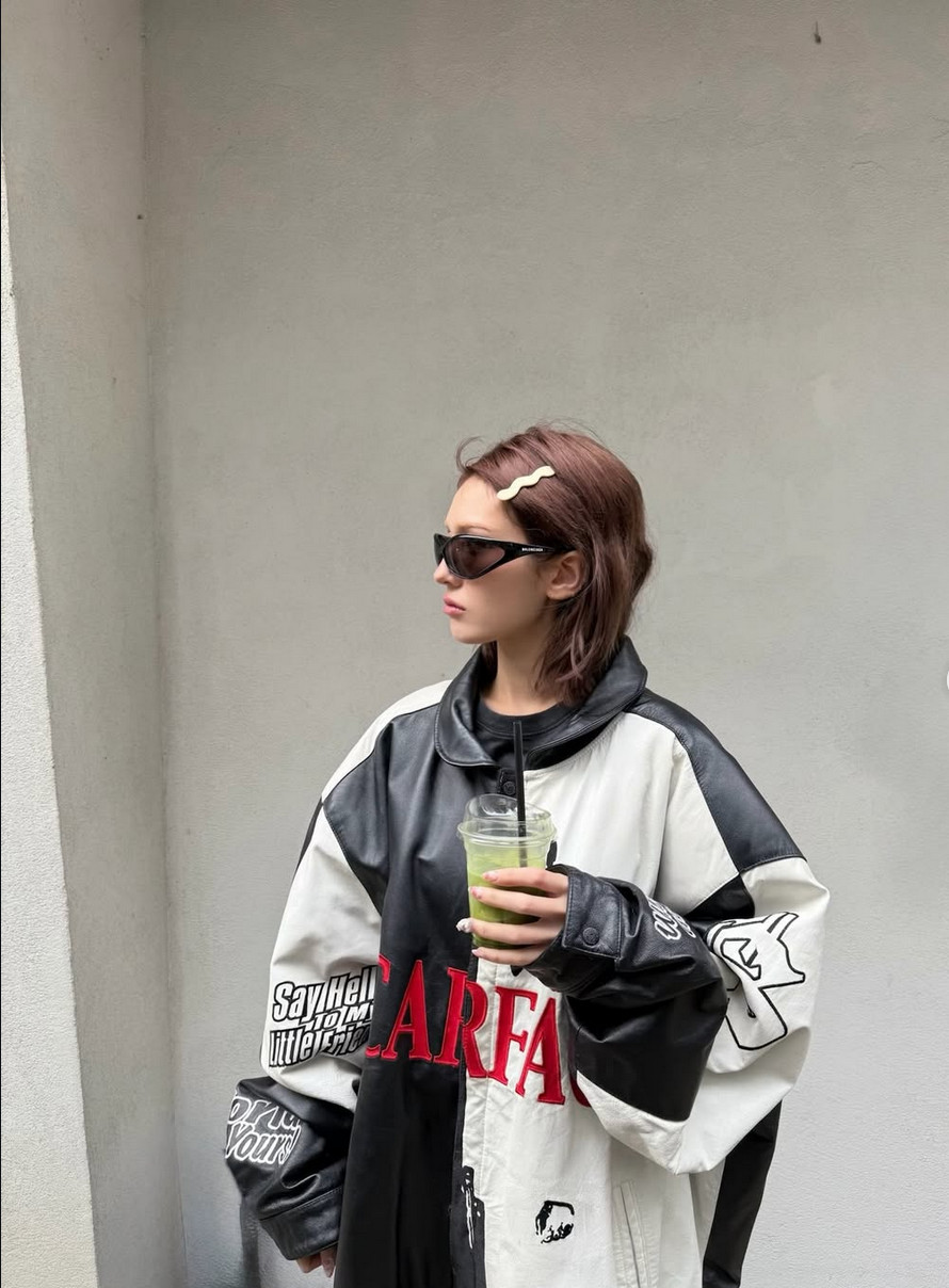 Somi in an oversized ‘Scarface’ racing jacket softened by a dainty yellow wavy hair clip (Photo: @somsomi0309/Instagram)