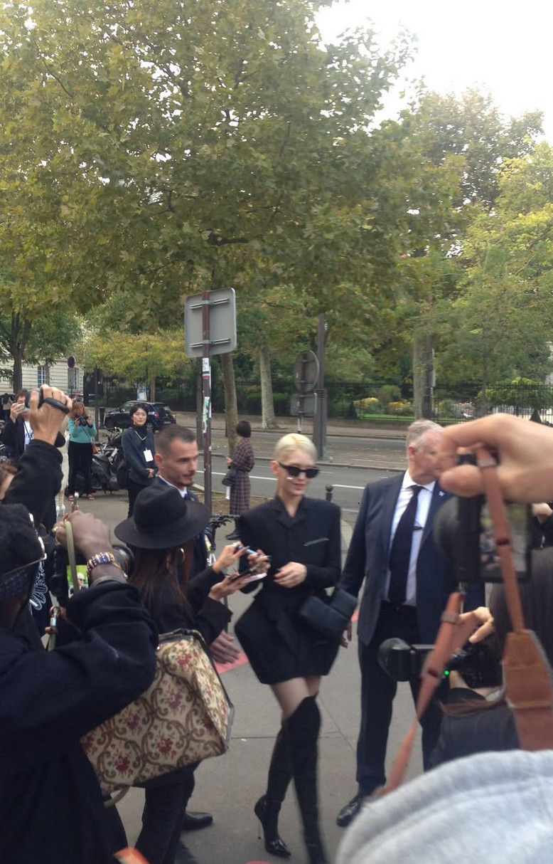Somi arrives at Fashion Week in a structural black blazer dress with slicked-back blonde hair and stiletto boots (Photo: @somsomi0309/Instagram)
