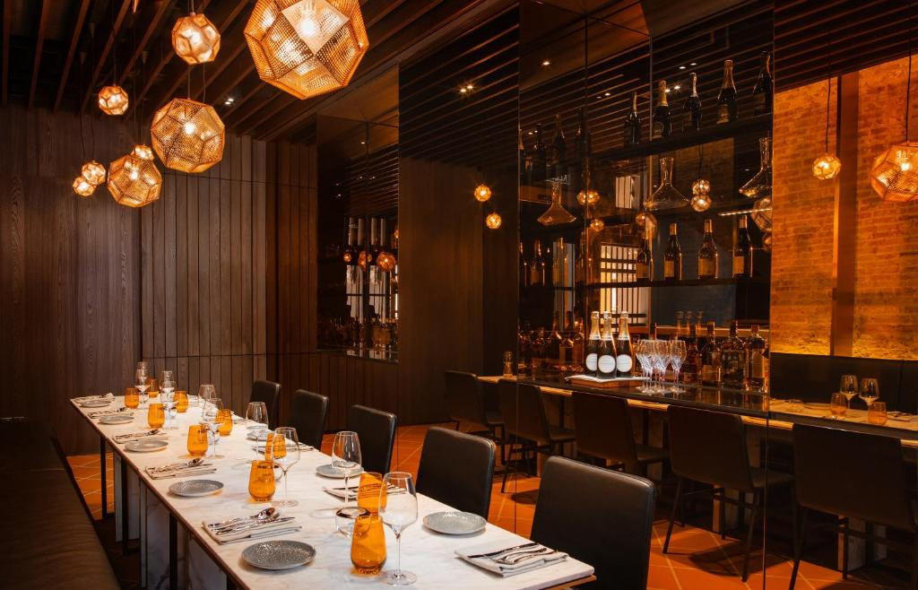 The private dining room at Tong, with shou-sugi ban panelling and copper-toned pendant lighting against the original shophouse brick