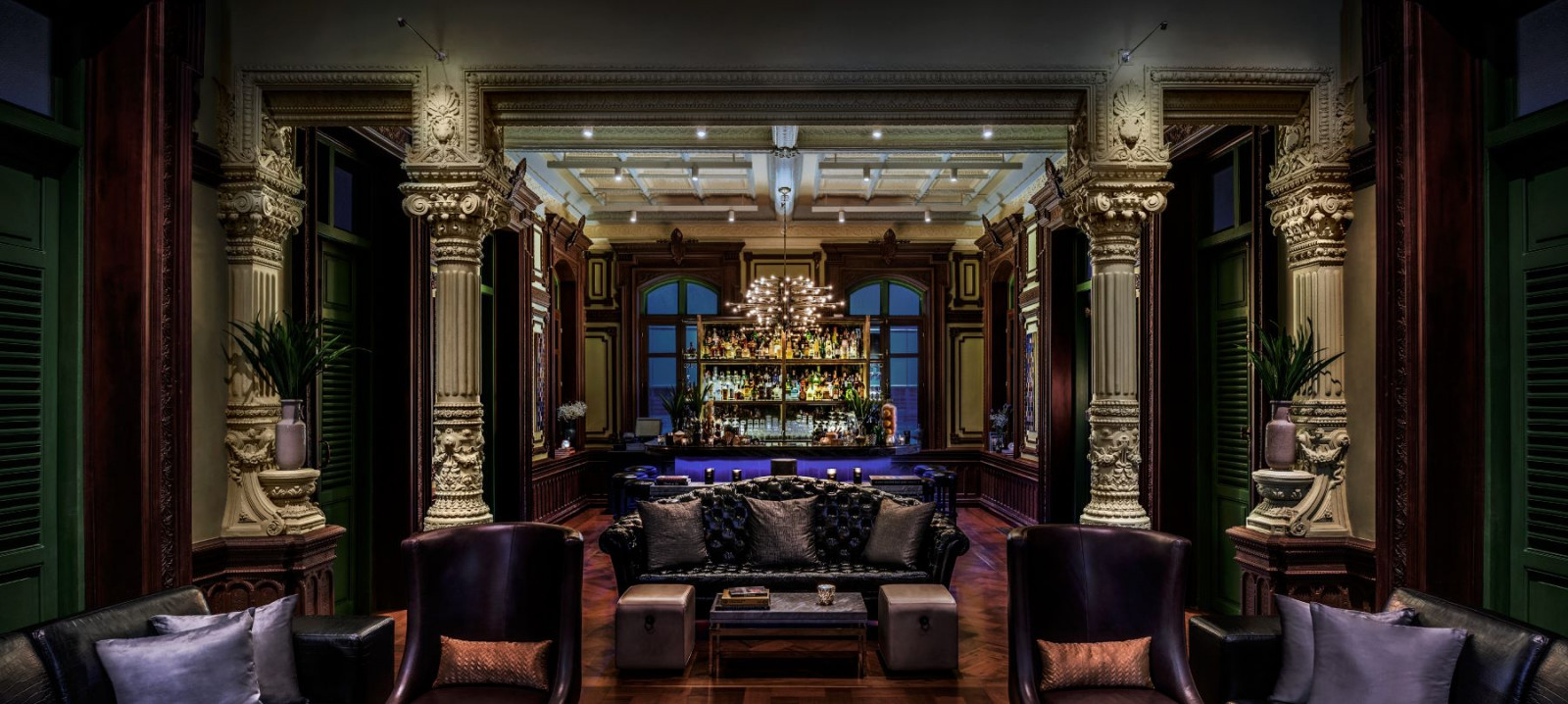The bar at The House on Sathorn, framed by the building’s original ornate plasterwork columns and coffered ceiling