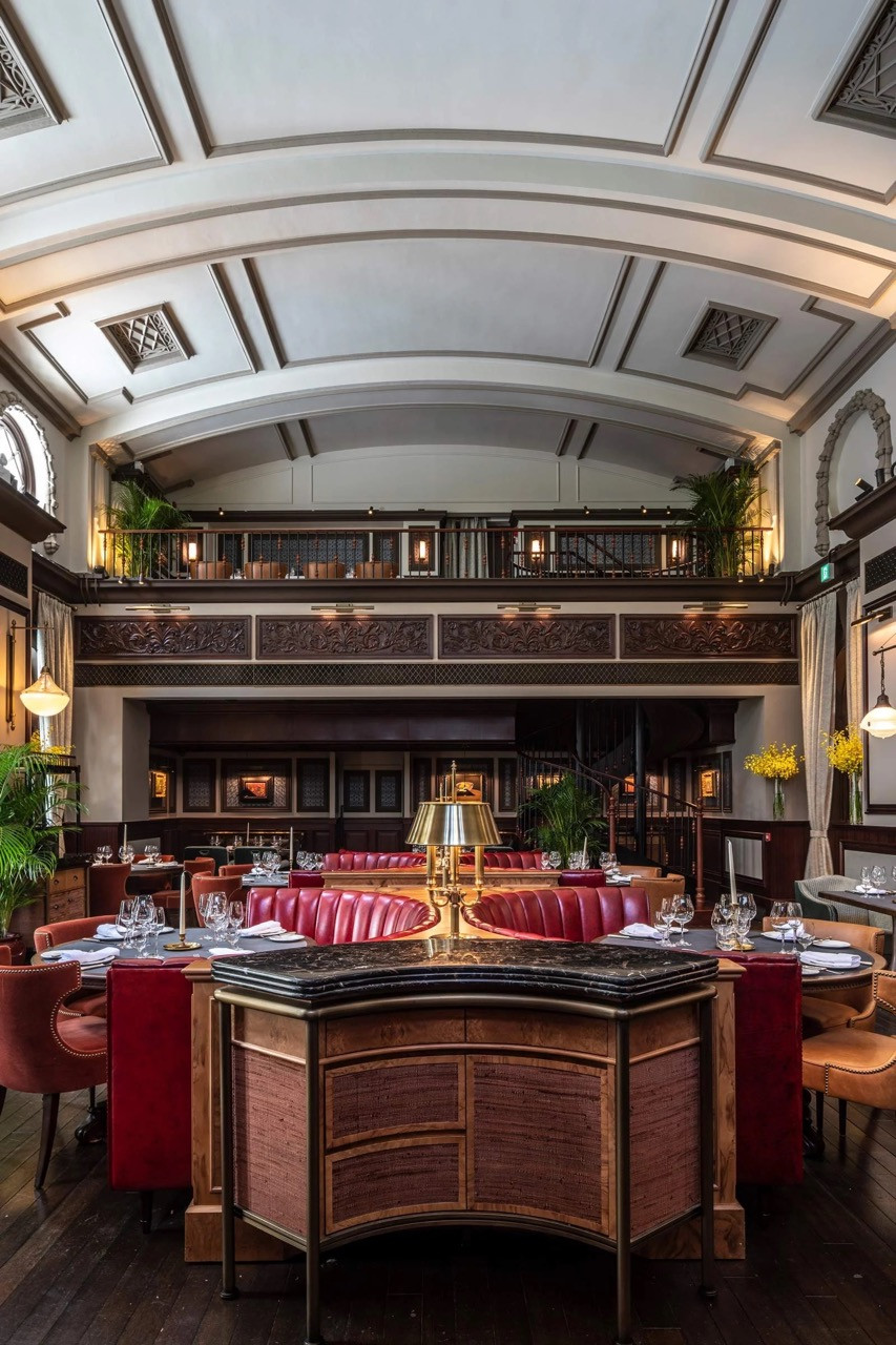The main dining room of The Magistracy at Tai Kwun, with Joyce Wang Studio’s interior set beneath the barrel-vaulted plasterwork ceiling of what was formerly one of Hong Kong’s central law courts