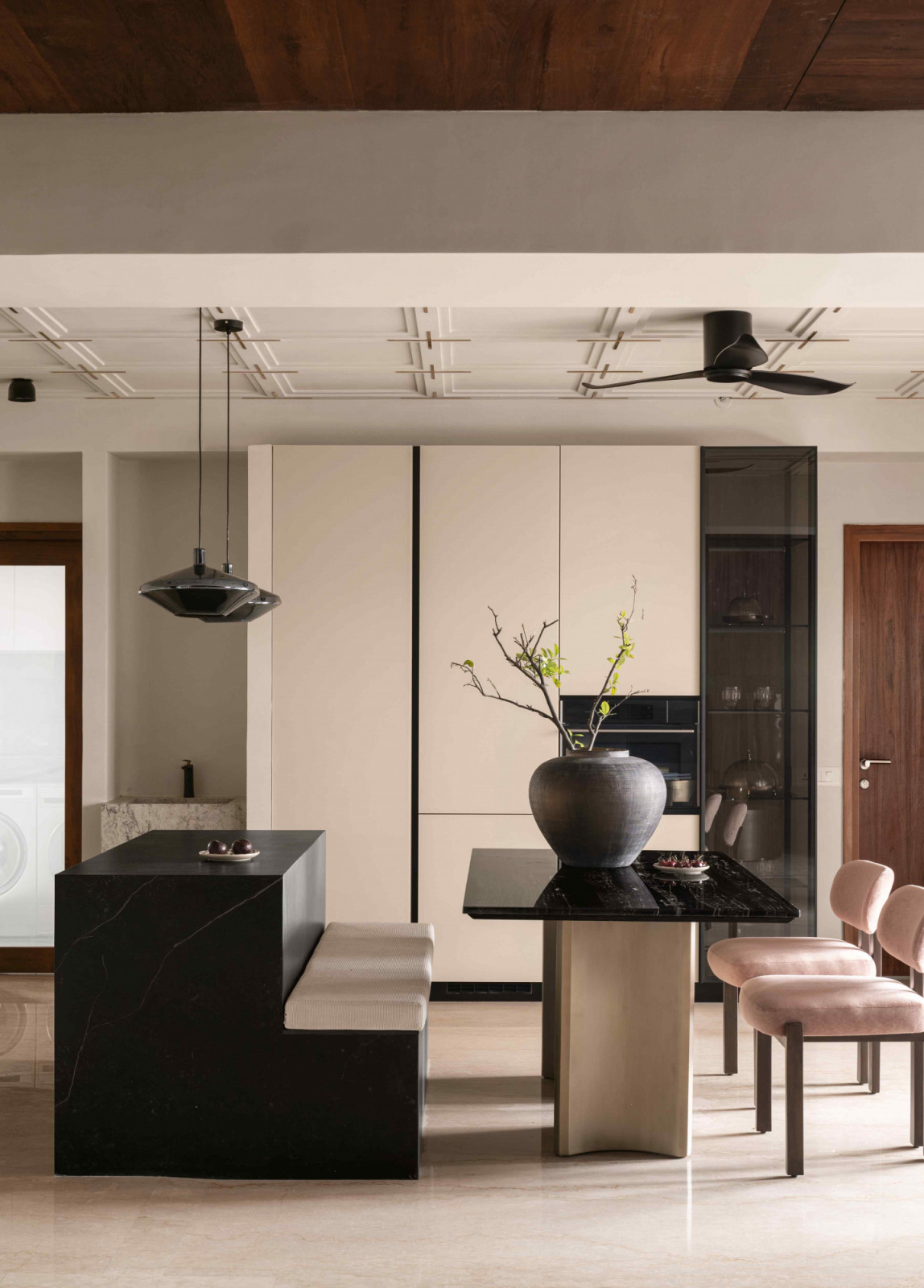 The kitchen counter transitions into bench seating for the dining table
