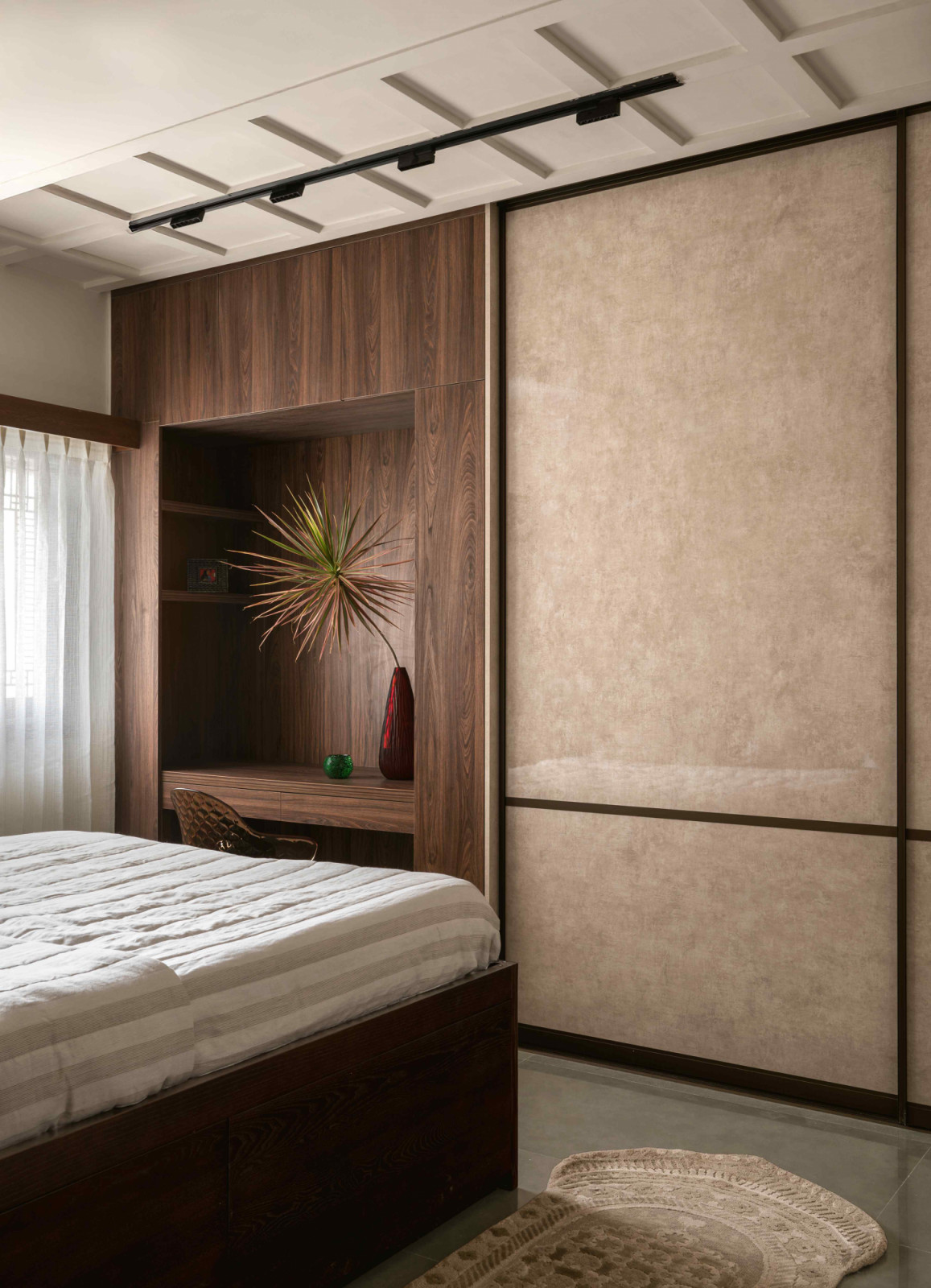 The beige textured finish of the floor-to-ceiling sliding wardrobe