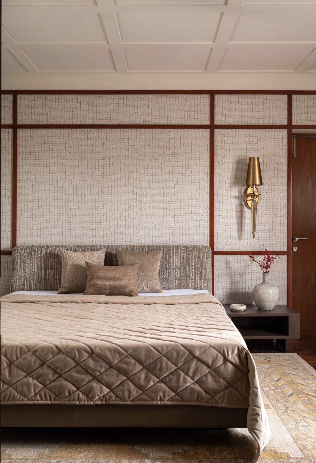 Wooden beading frames the fabric wallpaper in the master suite