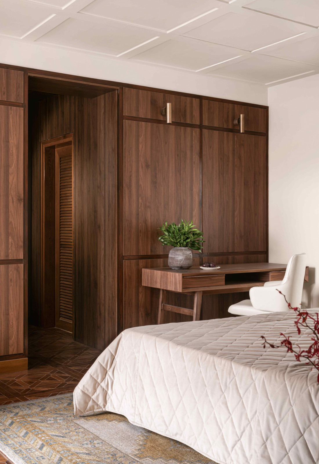 Warm, wooden wall panels conceal a walk-in wardrobe