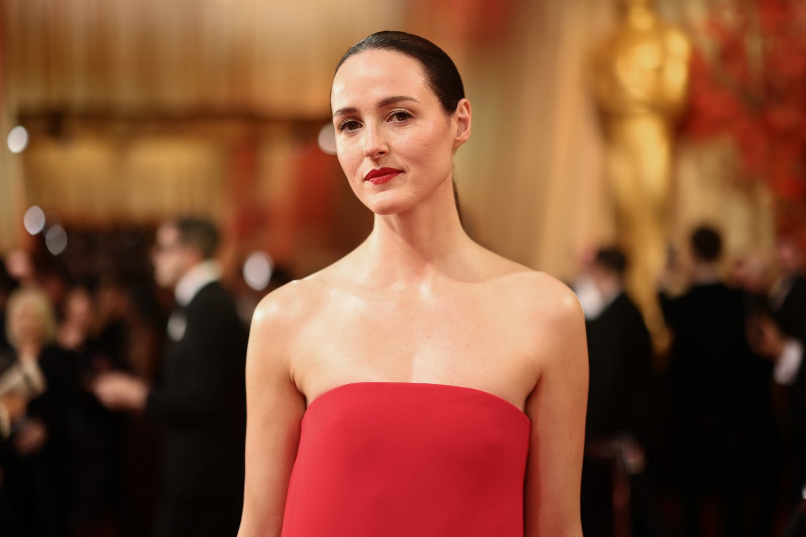 Renate Reinsve stunned in a custom red Louis Vuitton gown with asymmetrical bodice and square train, styled with a matching lip and sleek ponytail (Photo: Emma McIntyre/Getty Images)