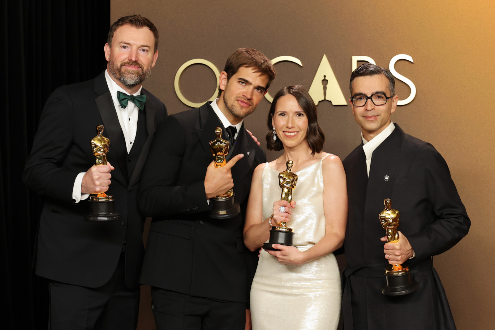 HOLLYWOOD, CALIFORNIA - MARCH 15: (L-R) Jack Piatt, Sam A. Davis, Natalie Musteata, and Alexandre Singh, winners of the Best Live Action Short Film Award for “The Singers” and “Two People Exchanging Saliva”, pose in the press room during the 98th Oscars at Dolby Theatre on March 15, 2026 in Hollywood, California. (Photo by Mike Coppola/Getty Images)