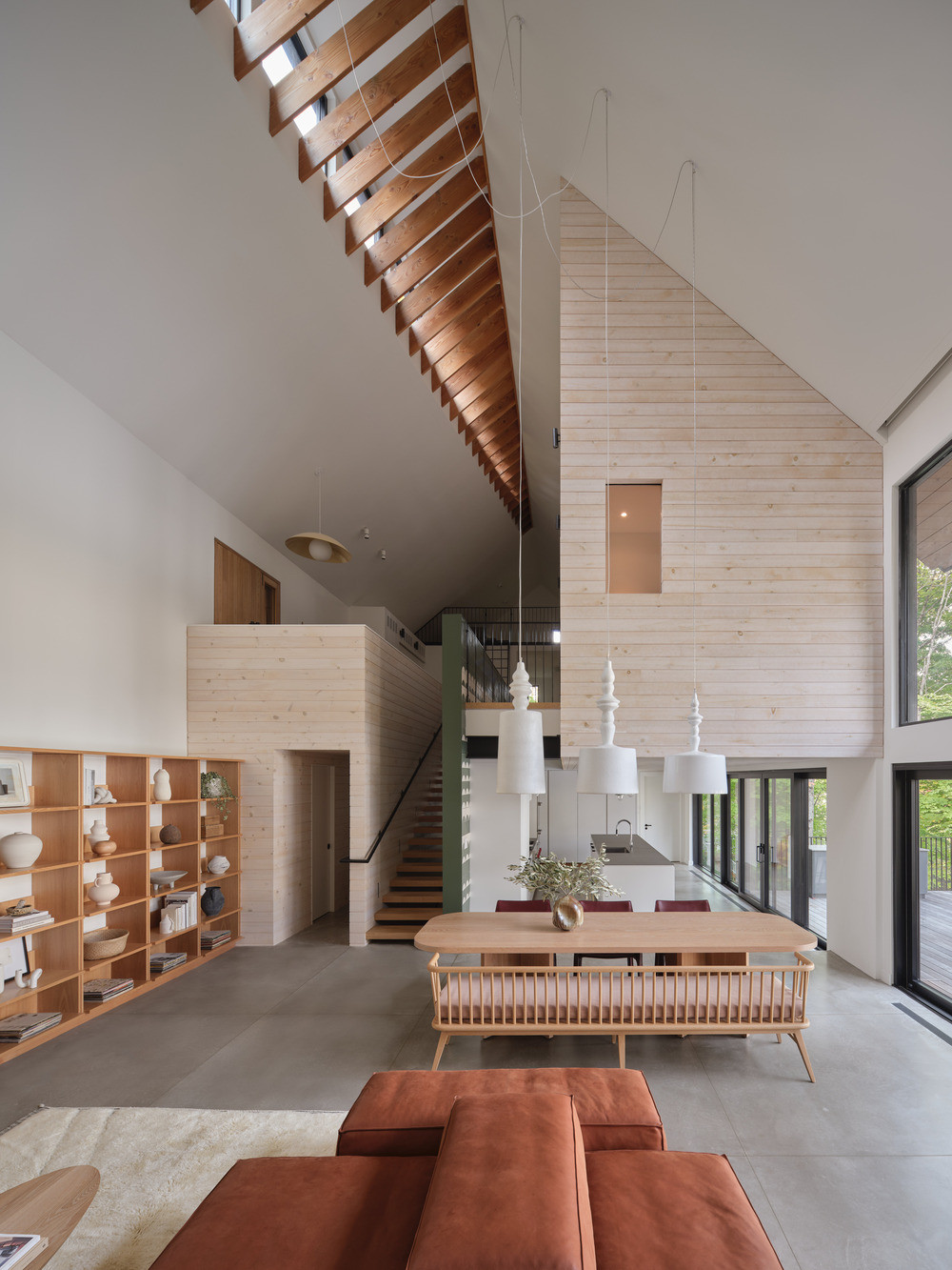 The double-height living space on the lower ground level, with exposed Douglas Fir joists following the pitch of the roof overhead