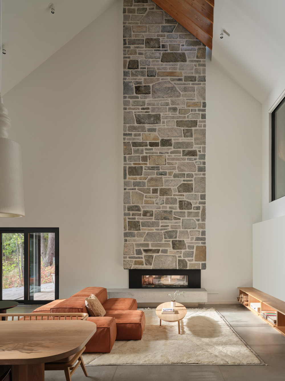The stone chimney rises through the double-height living space to the roofline