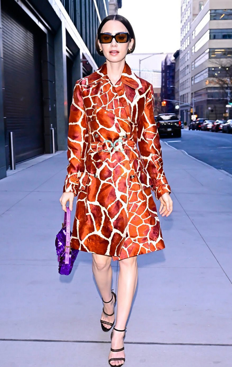 Lily Collins diện áo khoác dáng dài in họa tiết hươu cao cổ hiệu Roberto Cavalli năm 2006, thắt eo ở New York