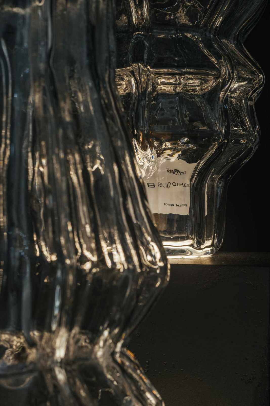 A close-up of a Byredo candle peeking behind an Iittala glass vessel