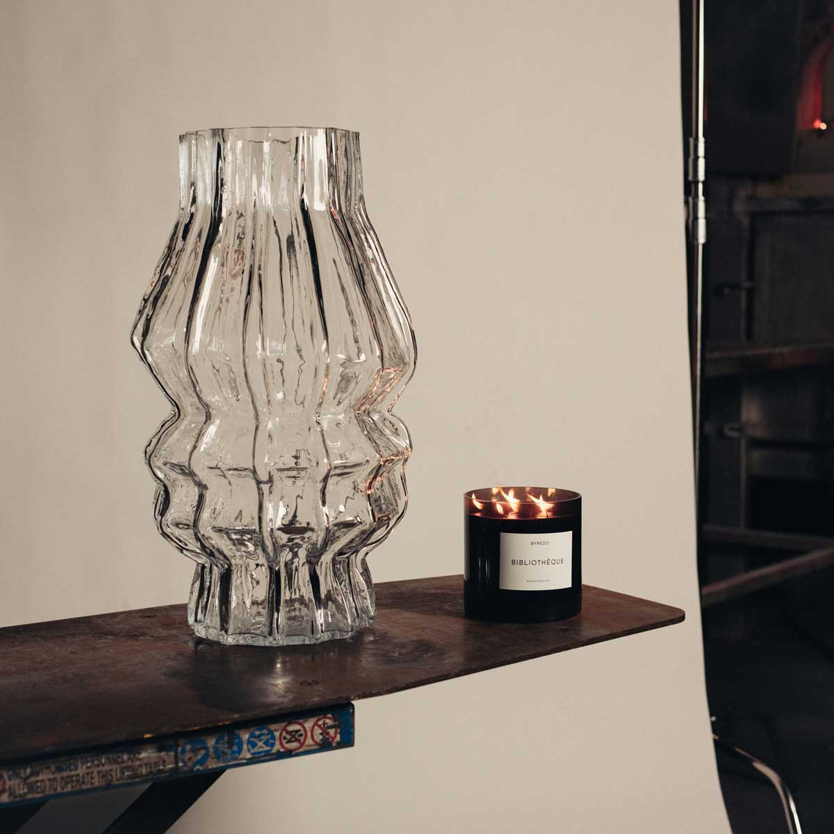 A handcrafted Iittala glass vessel next to Byredo’s Bibliotheque candle