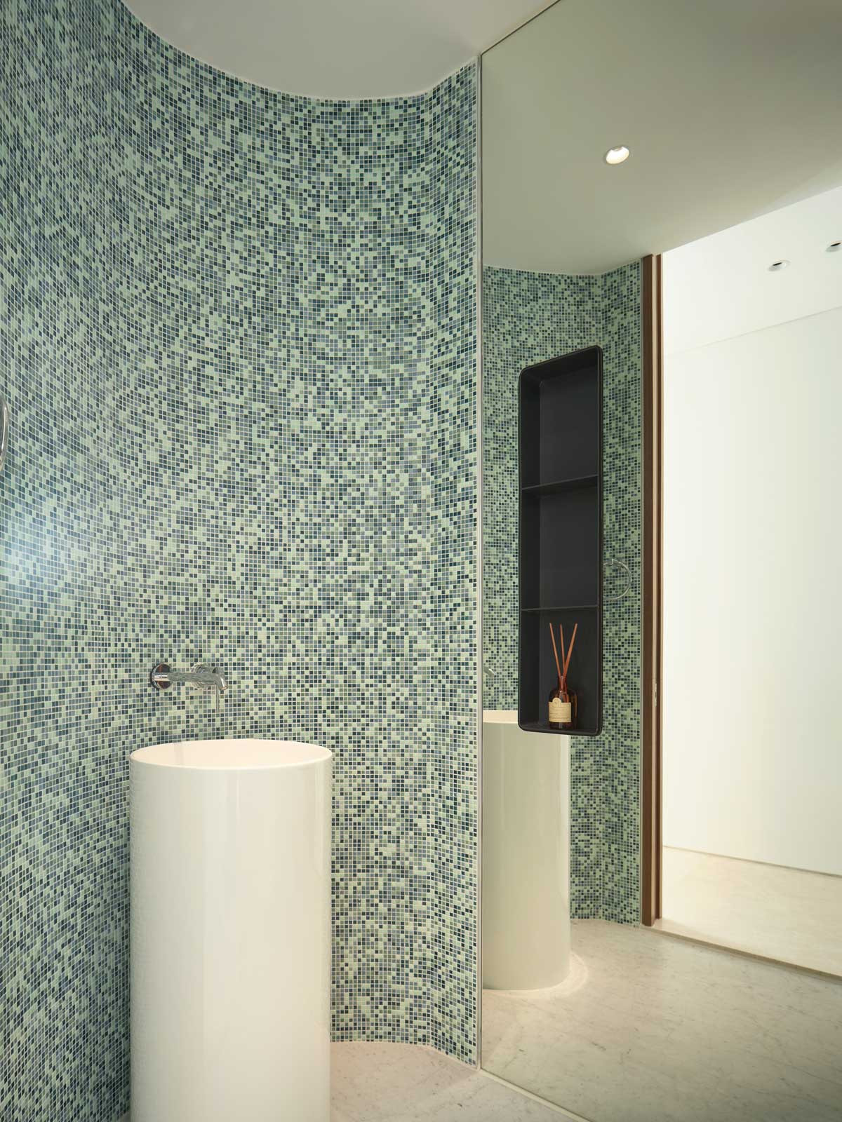 Mirrored surfaces and mosaic tiles make for a stunning powder room