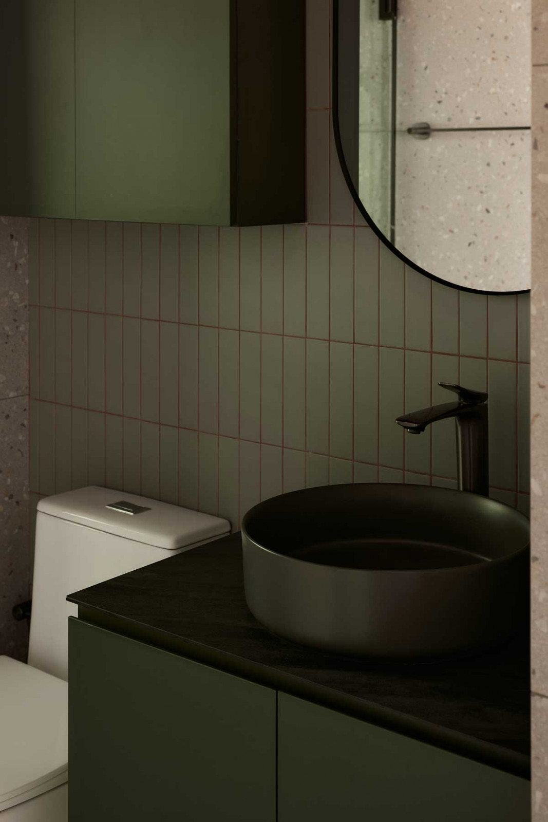 Calming green tones anchor one bathroom
