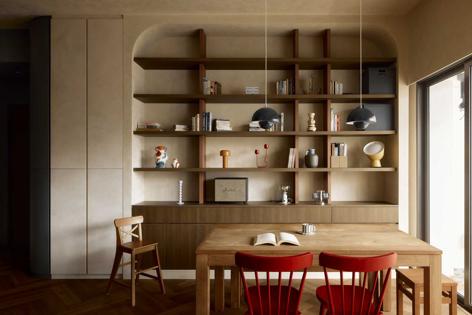 Curved niches and built-in shelving soften the structure of the apartment and provide display spaces for books and personal objects