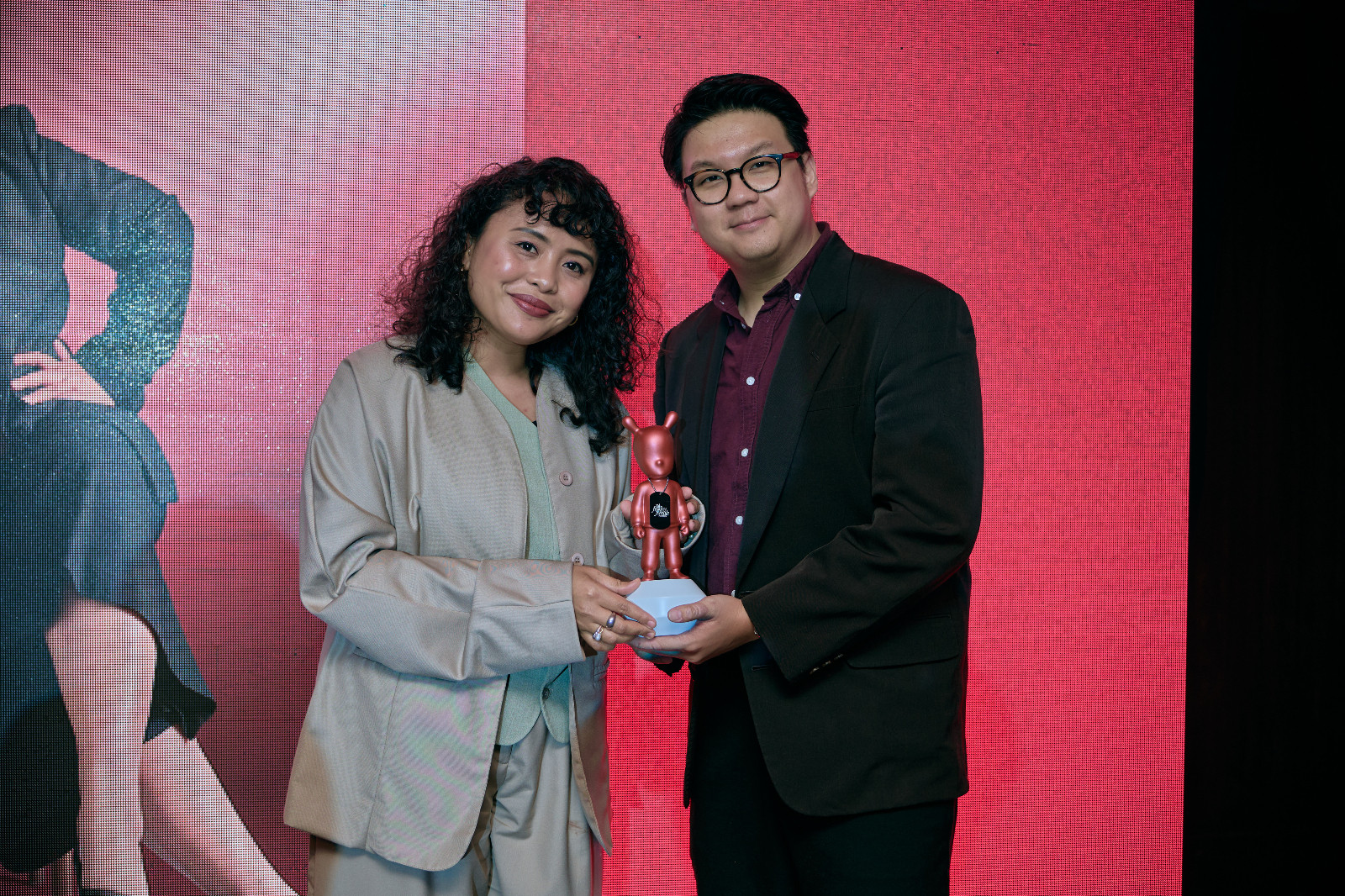 Natasha Meera Riduan accepts the Lladró trophy from Tatler Malaysia general manager, Sim Wie Boon on behalf of Social Impact Award winner, Viviantie Sarjuni