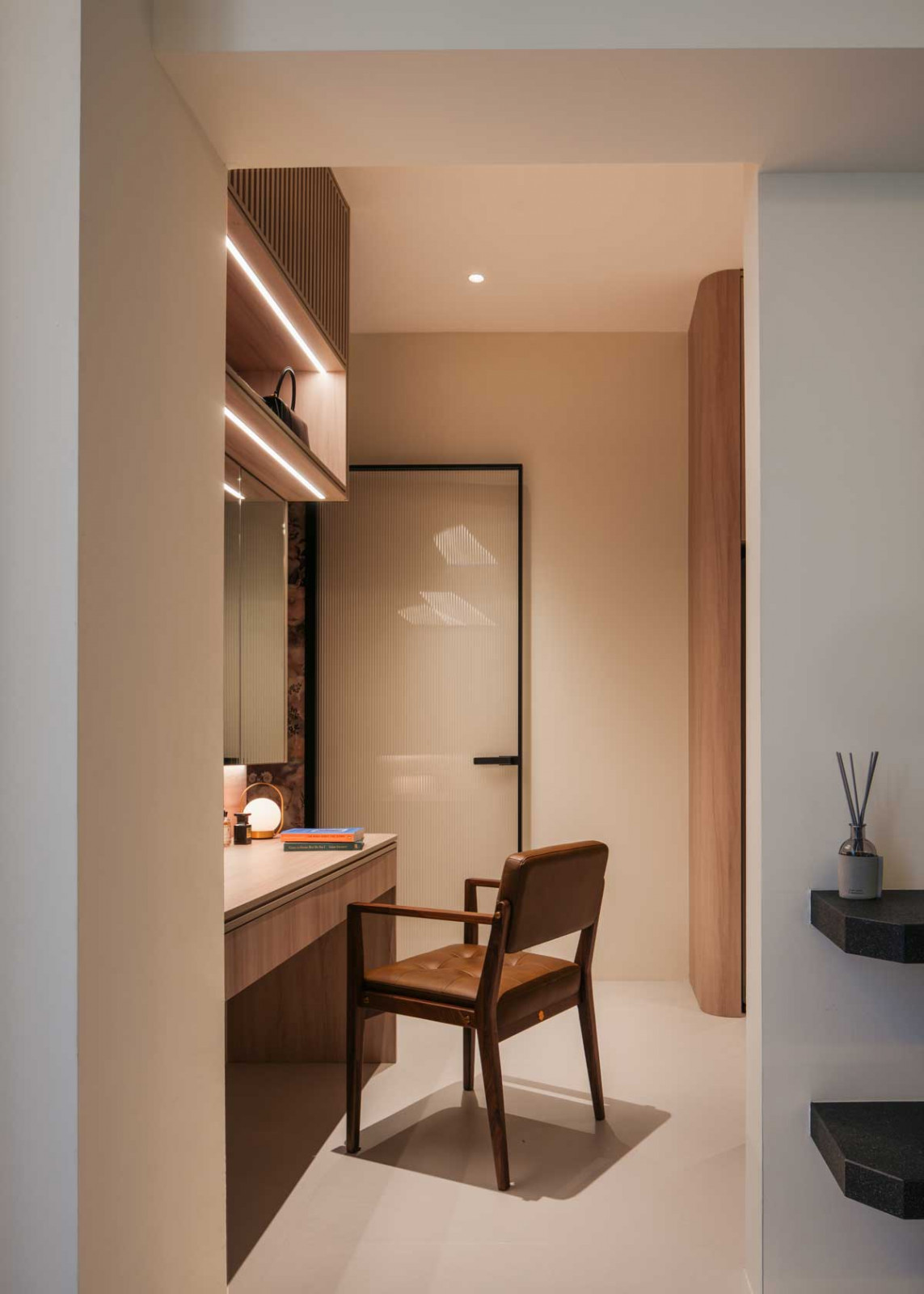 Light-toned timber and curved carpentry foster a sense of gentle retreat in the master bedroom