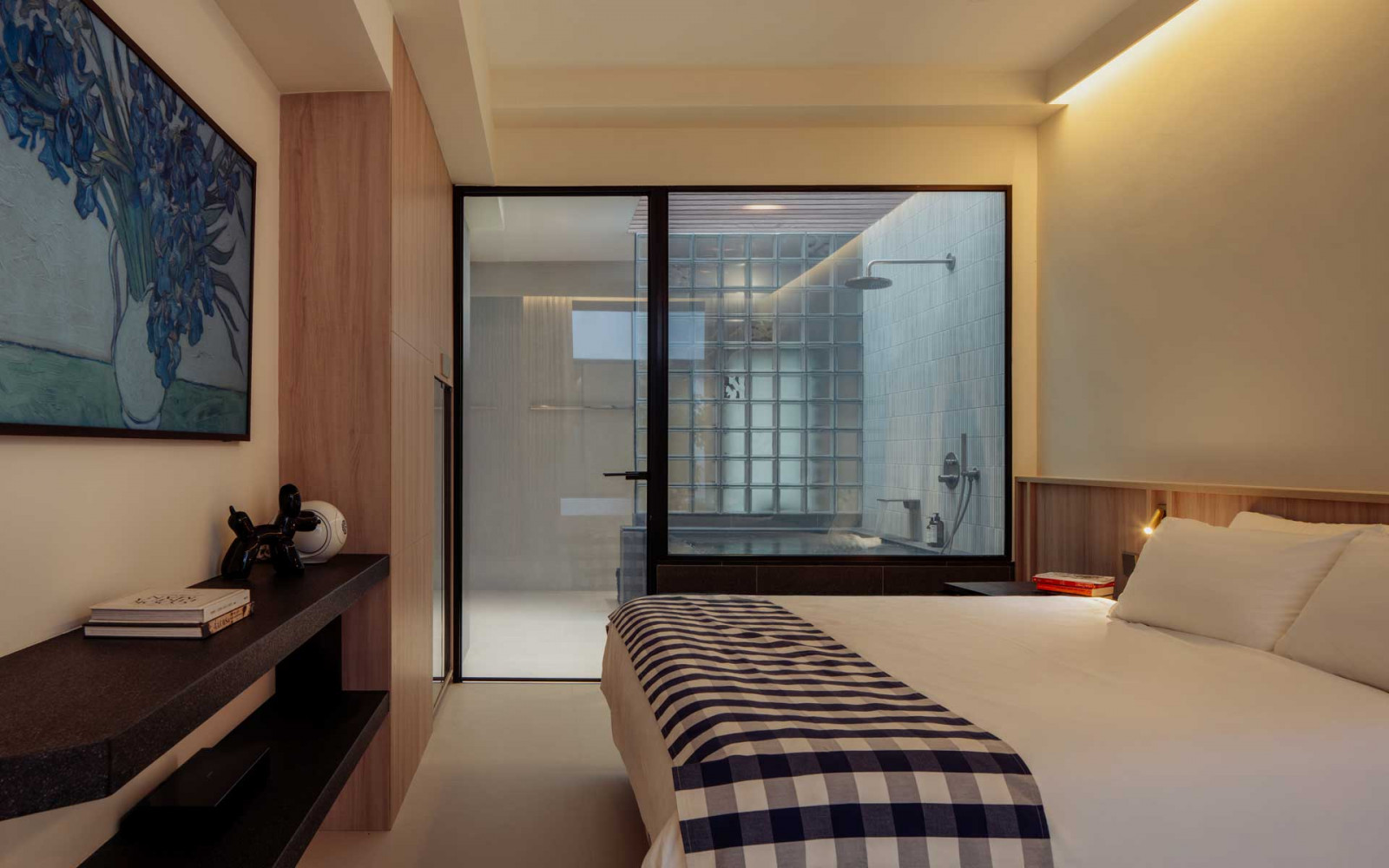 A smart glass panel separates the bedroom from the bathing area