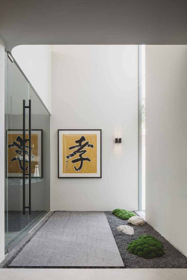 A smaller rock garden lines the walkway, paired with artwork from the homeowner’s personal collection