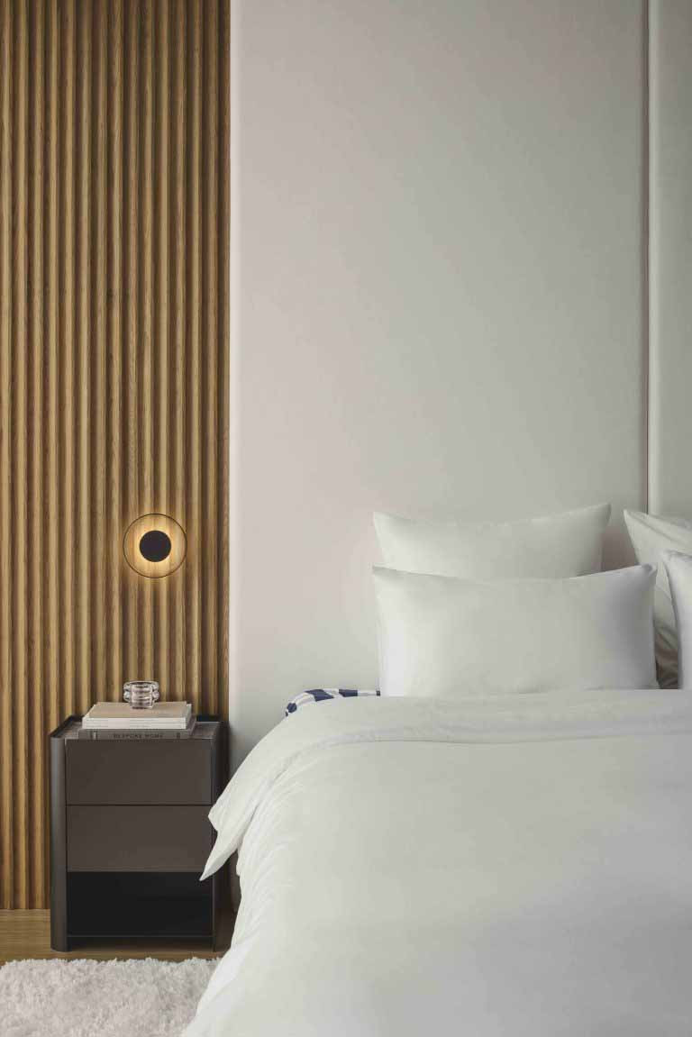 The semi-detached home’s bedroom continues the home’s restrained material palette