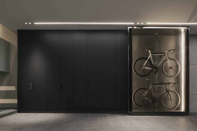 A display niche showcases bicycles within the basement, framed by dark cabinetry