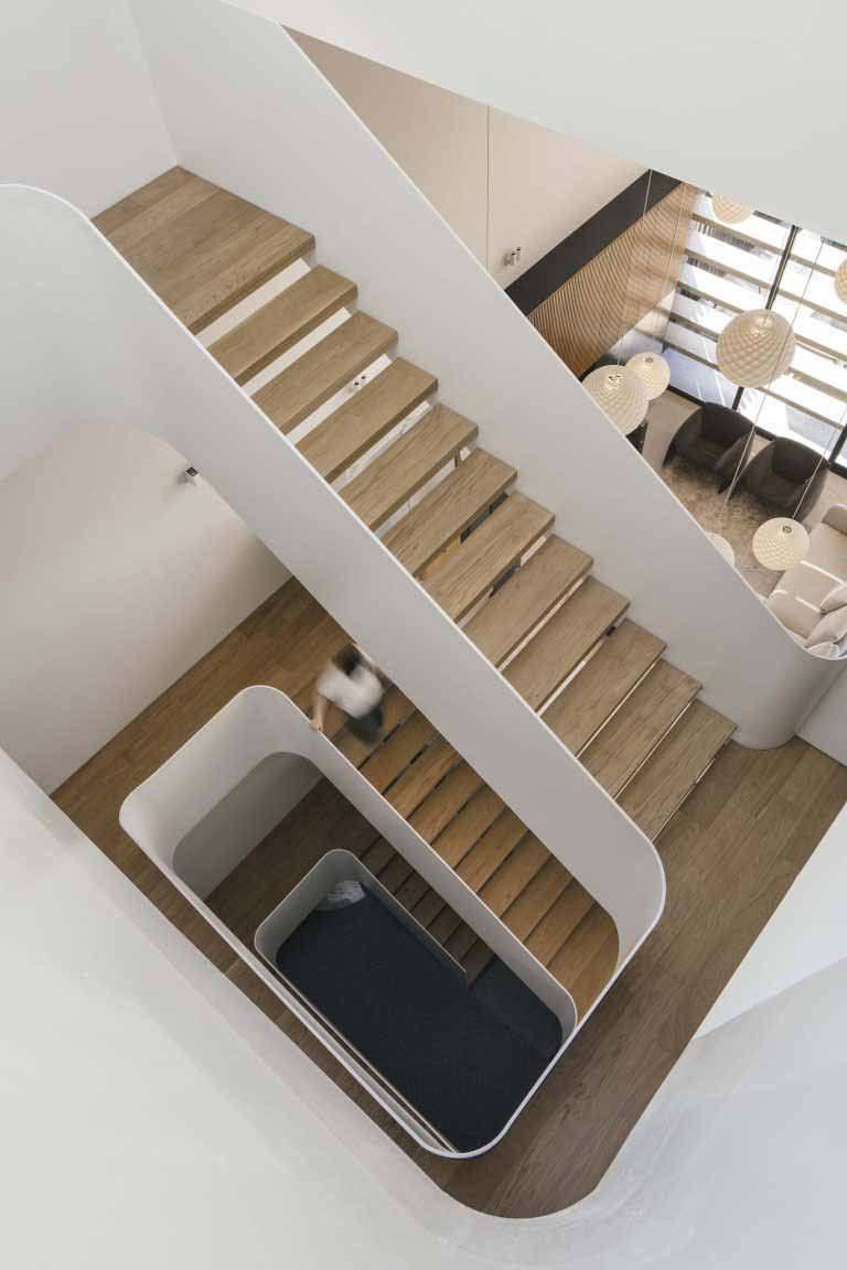 The semi-detached home’s staircase is conceived as a large open void, connecting the attic to the ground floor below