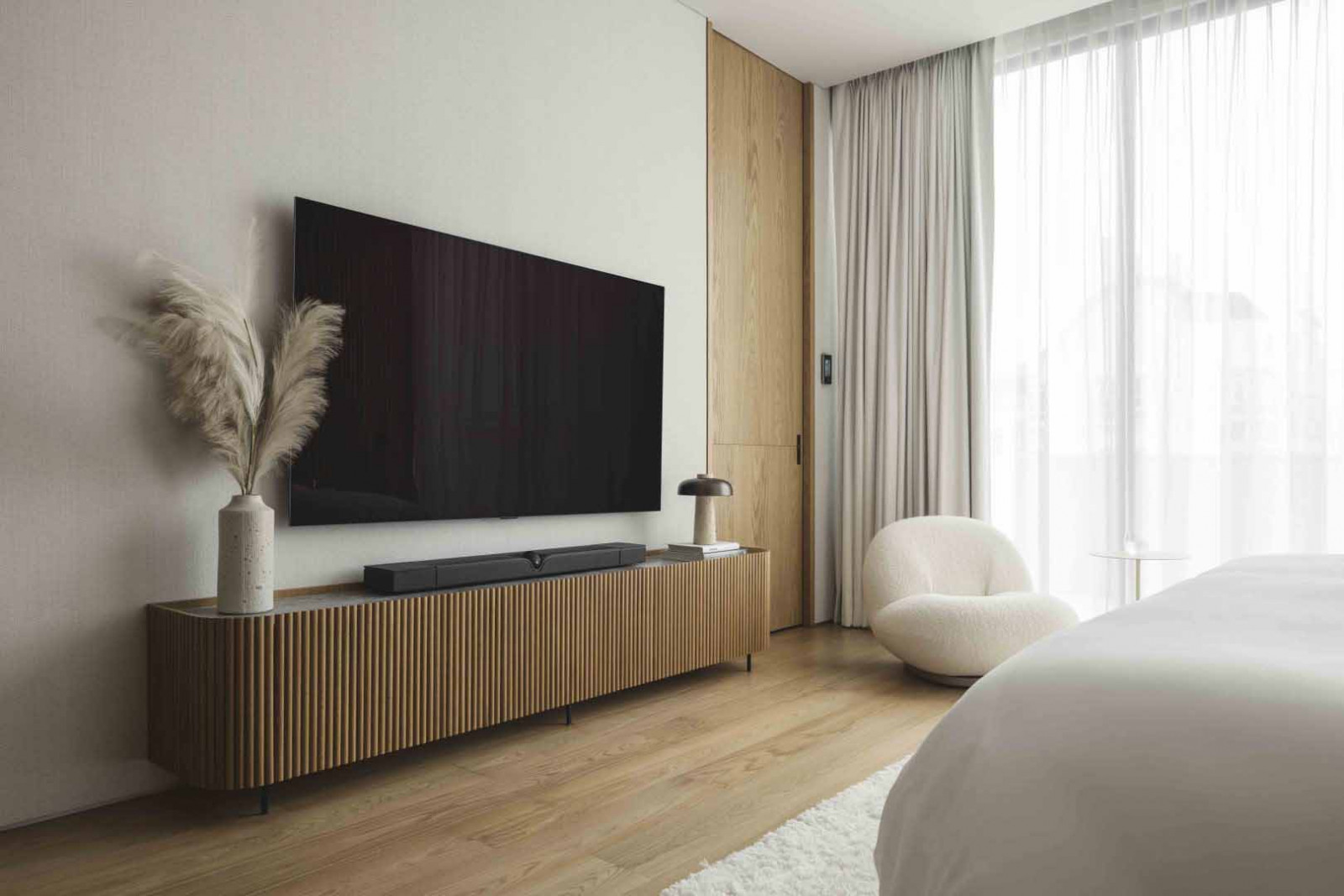 A fluted detail appears in the bedroom carpentry, echoing the home’s controlled material language.