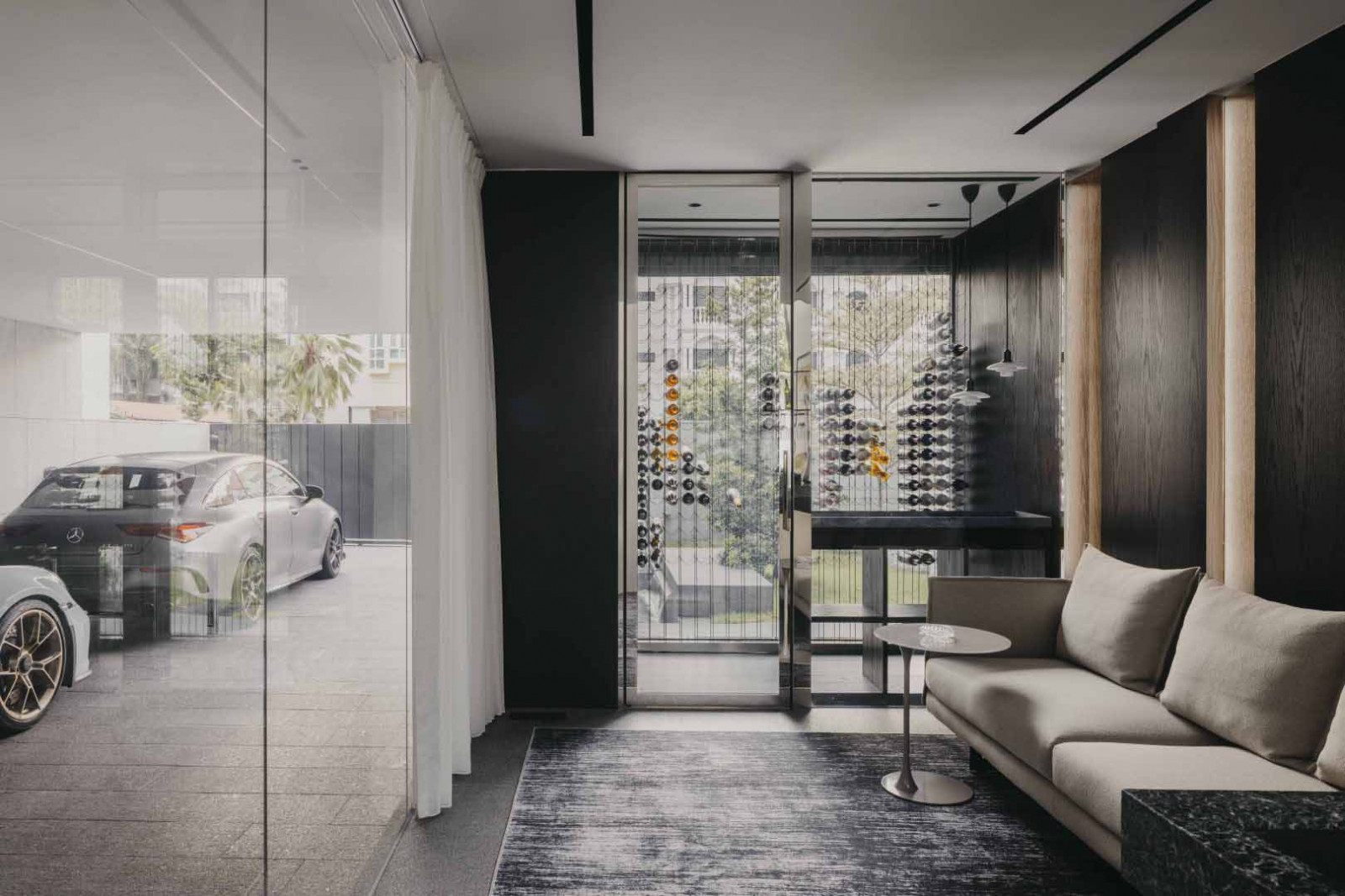 The lounge opens towards the exterior, with views through layered screens and glazing