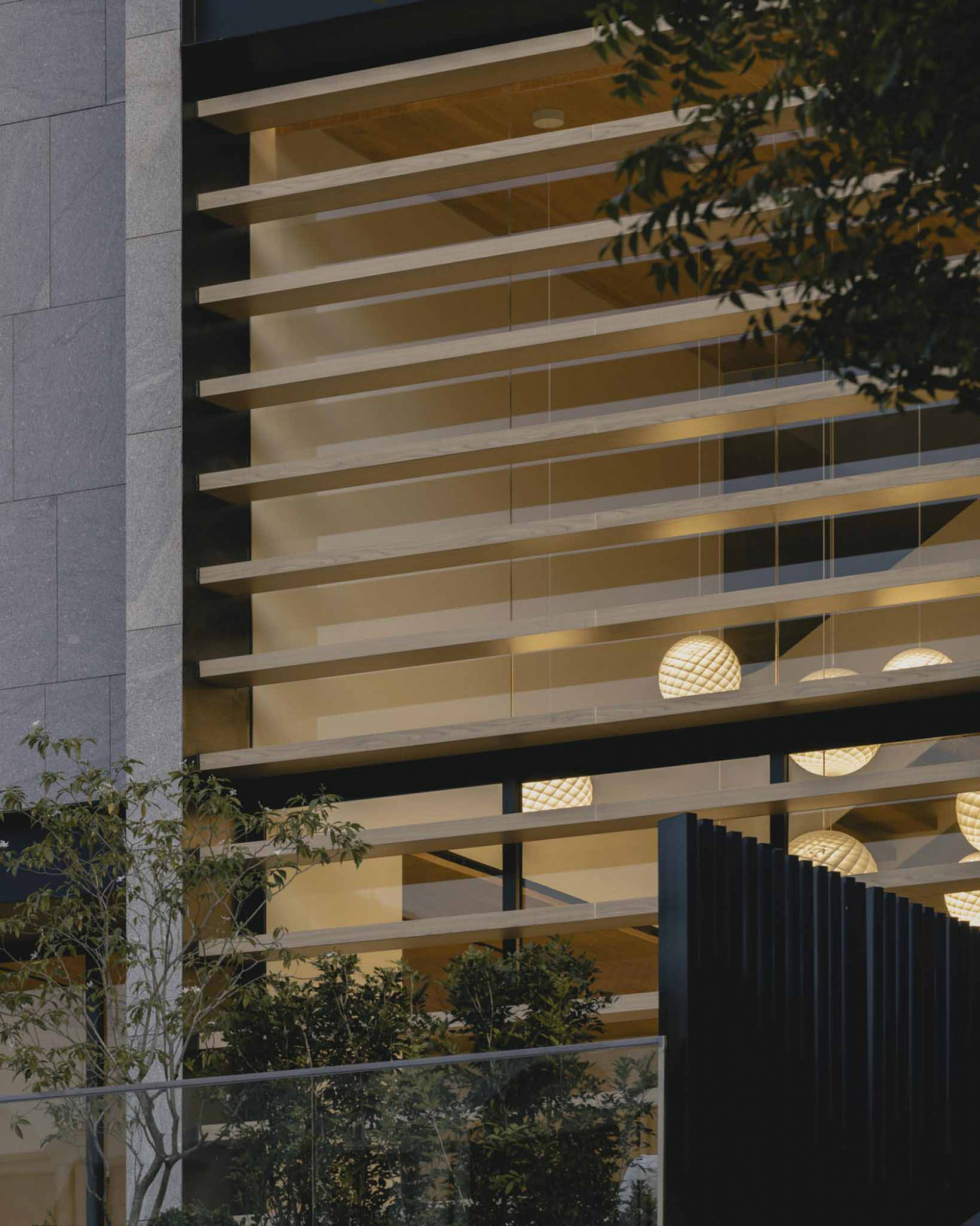 External screens provide privacy and shade control for the double-height living area facing the street