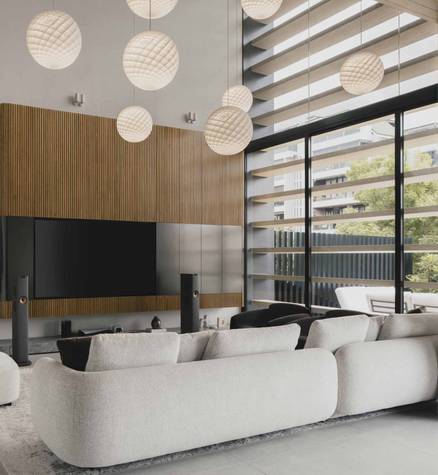 A double-height void with tall openings enhances natural illumination in the main living area