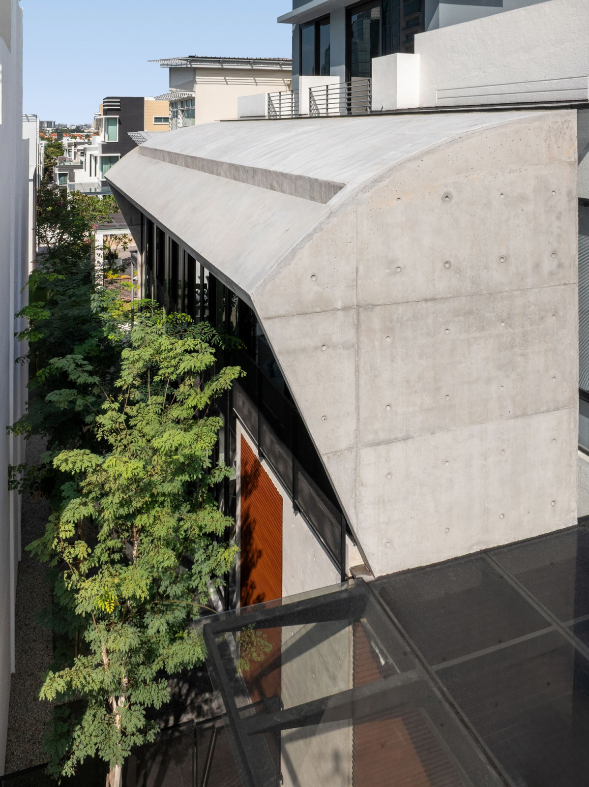 The curved off-form concrete roof of the new extension, seen from above, spans the double-height hall without intermediate support