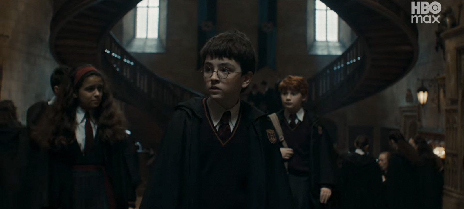 Harry, Ron and Hermione walks the halls of Hogwarts ( (Screencap from YouTube)