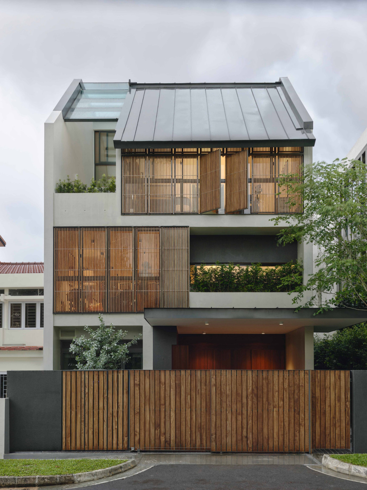 The street-facing elevation shows the terrace house’s concrete shell framed by operable timber screens