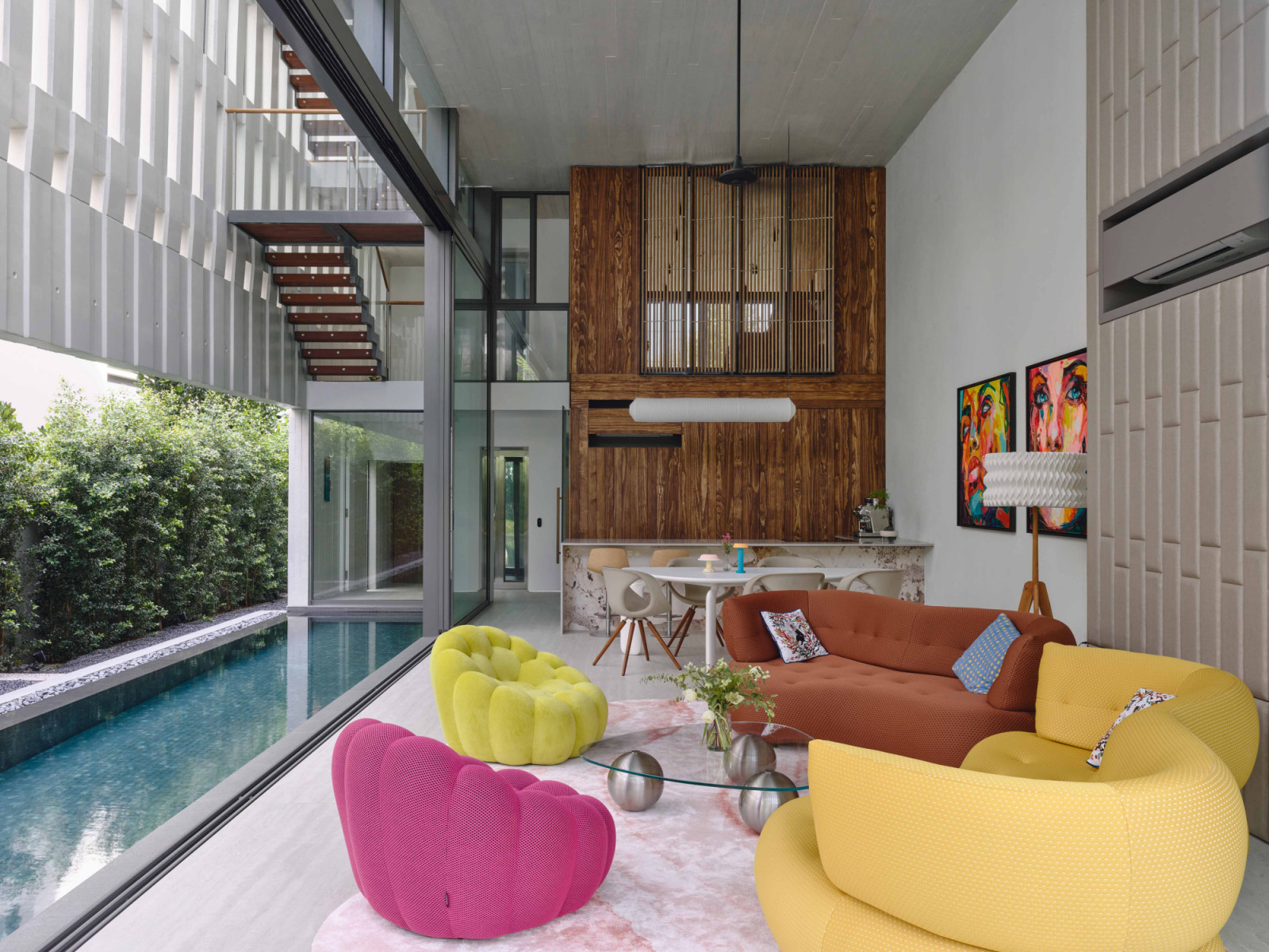 Colourful furniture and timber accents add a playful contrast to the formality of the terrace house’s concrete frame