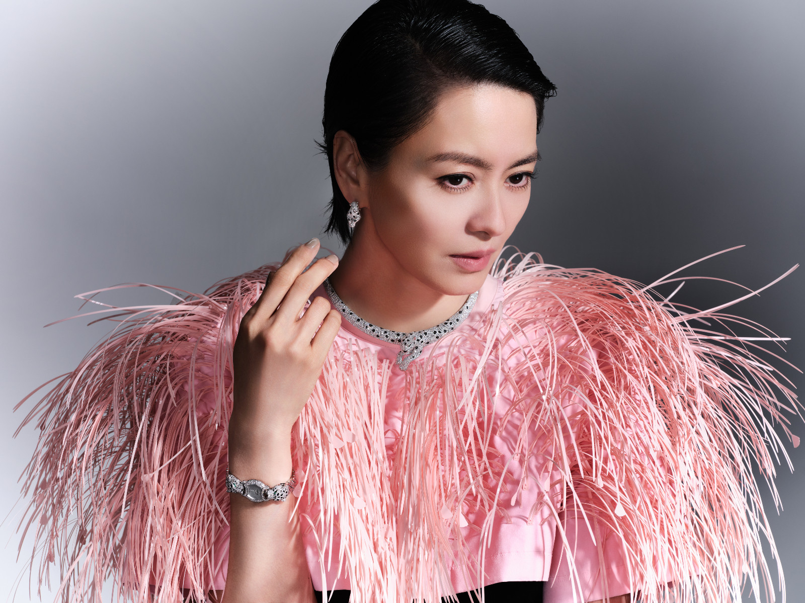 Gigi Leung wears Cartier Panthère Onca necklace, earrings in white gold, onyx and diamonds, Cartier Baignoire watch in white gold, emeralds and diamonds; Balenciaga top